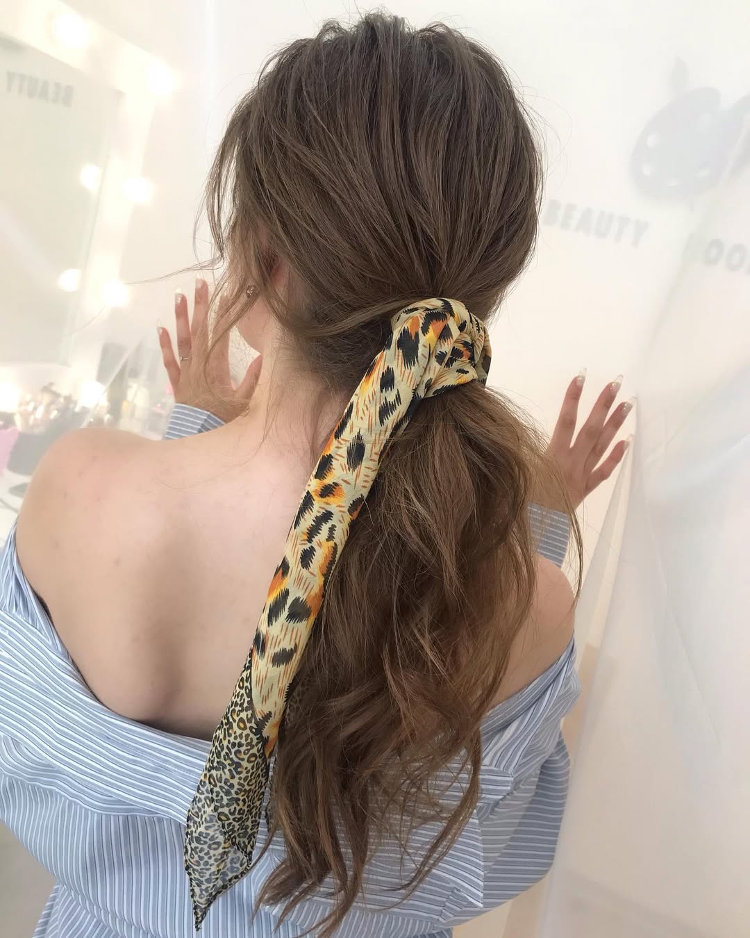 Chic Low Ponytail With Bold Leopard Scarf Accent