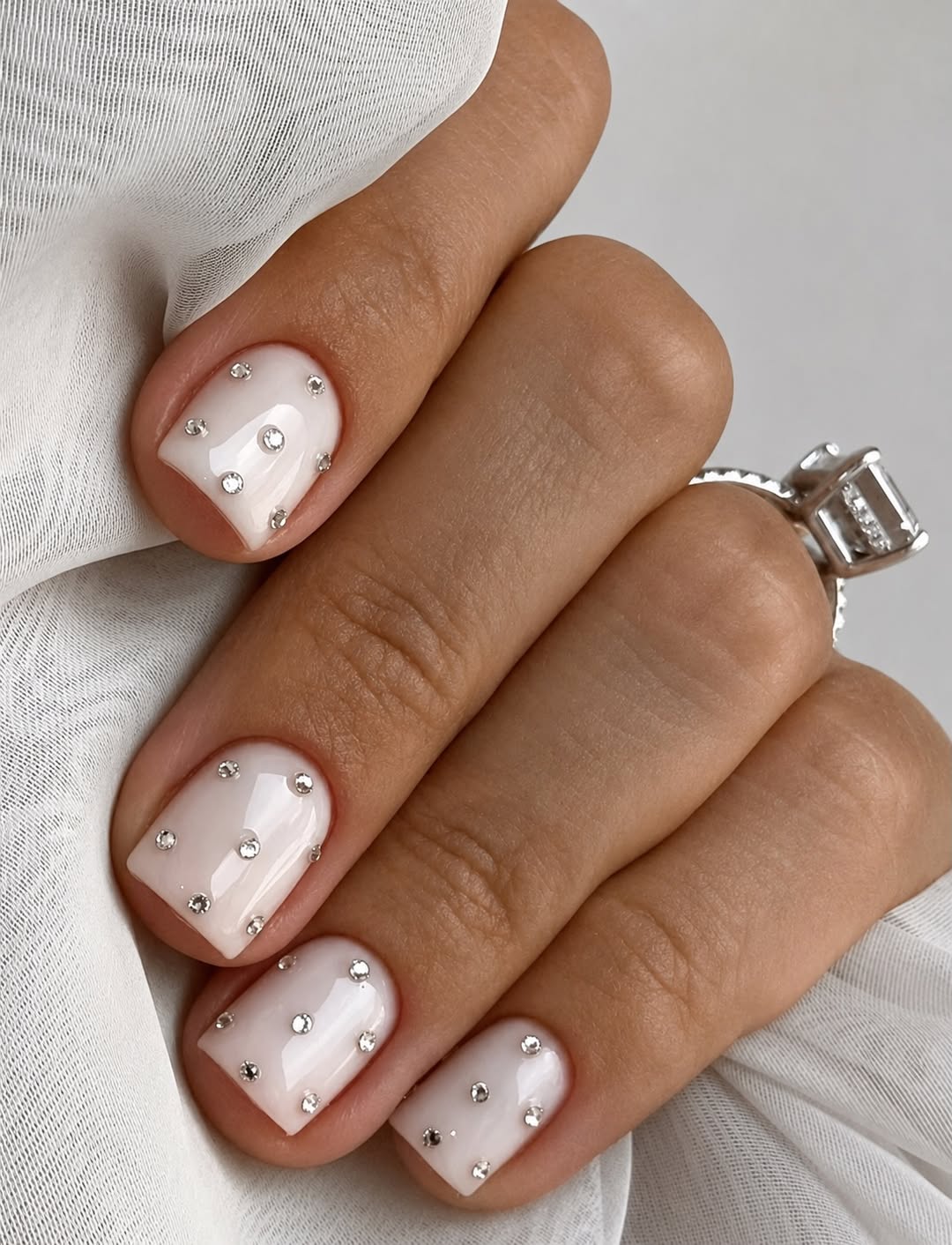 Dainty Milky White Nails With Rhinestone Embellishments