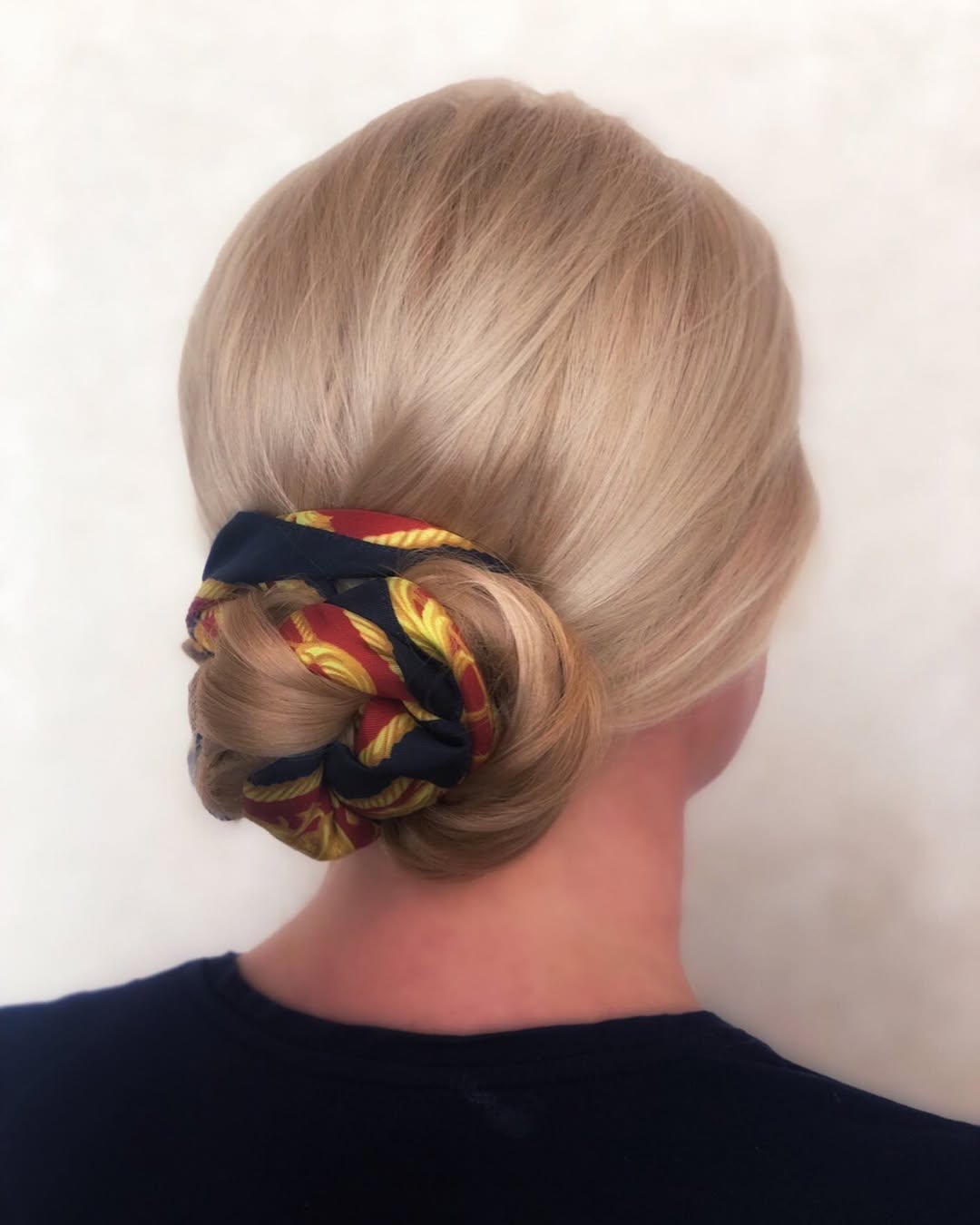 Elegant Blonde Chignon with Silky Scarf Accent