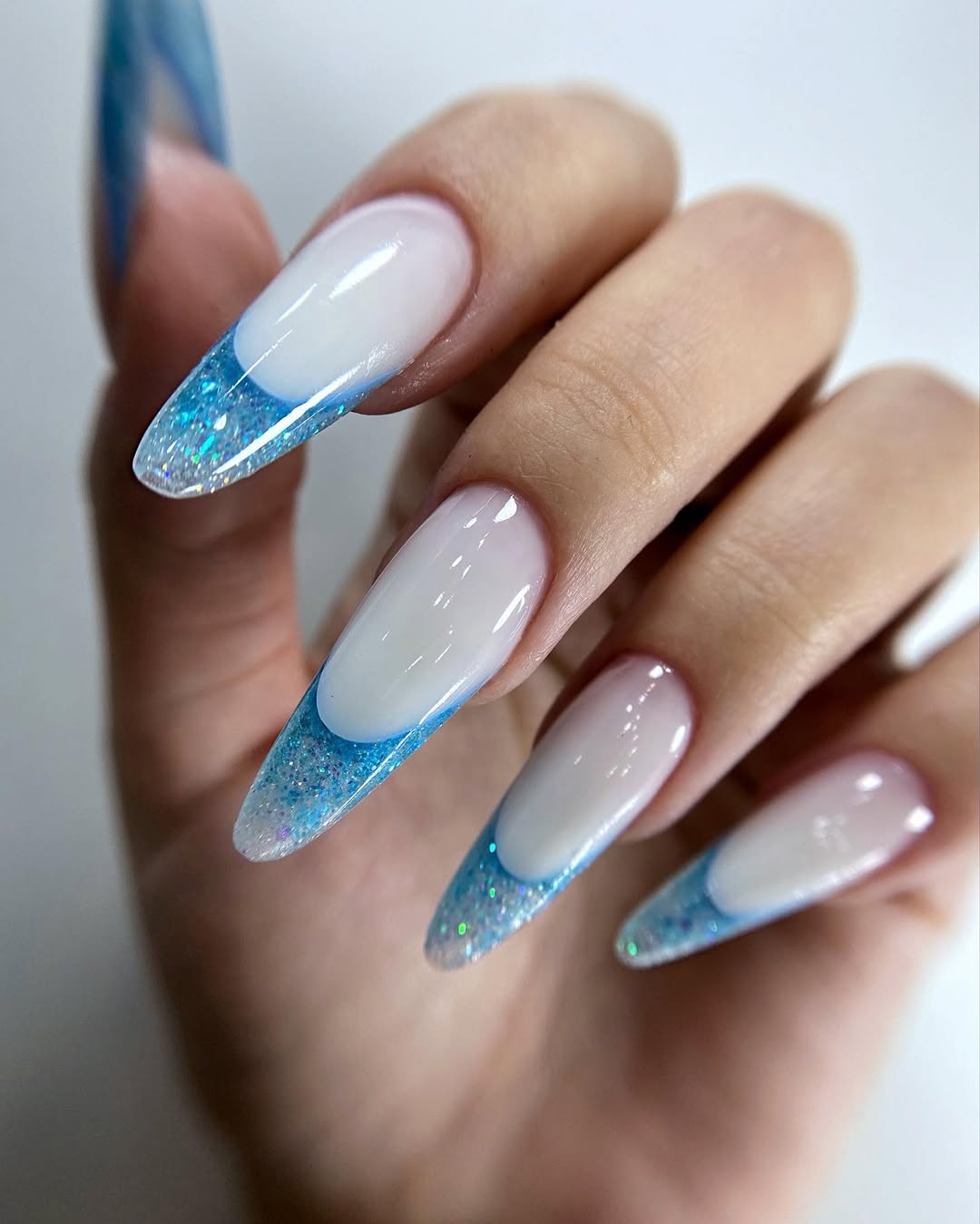 Glittery Ocean Blue French Tip Almond Nails