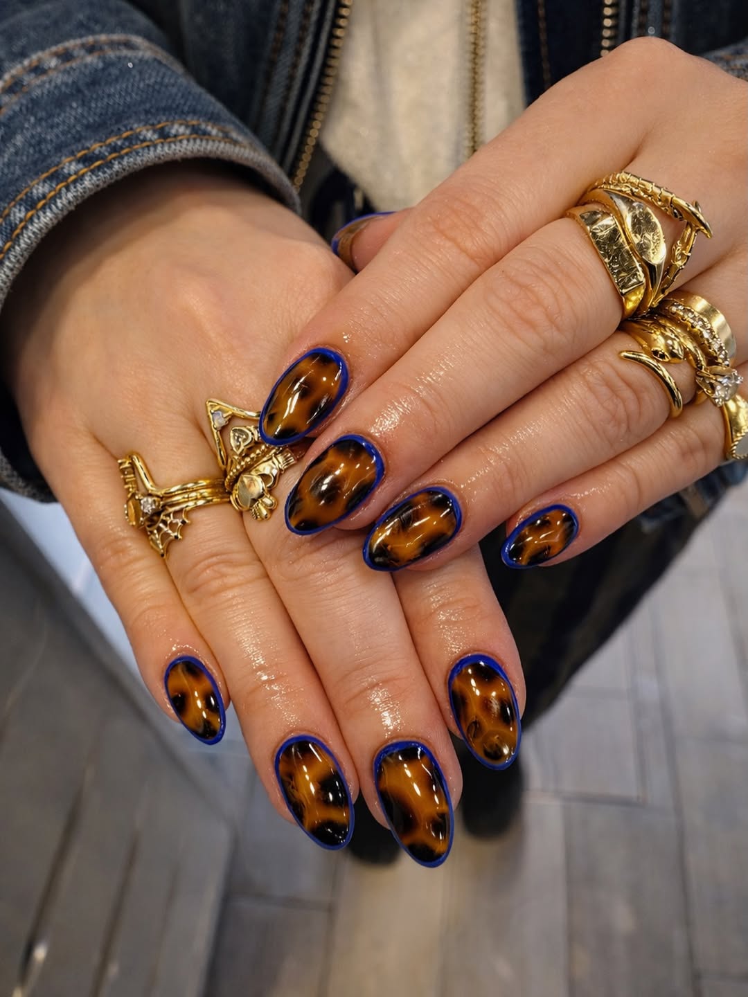 Glossy Tortoise Shell Almond Nails with Royal Blue Outline
