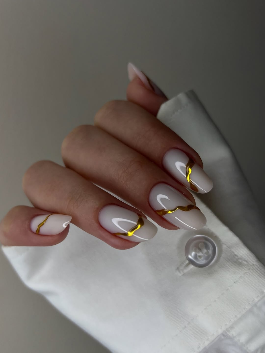 Milky White Oval Nails with Gold Swirls