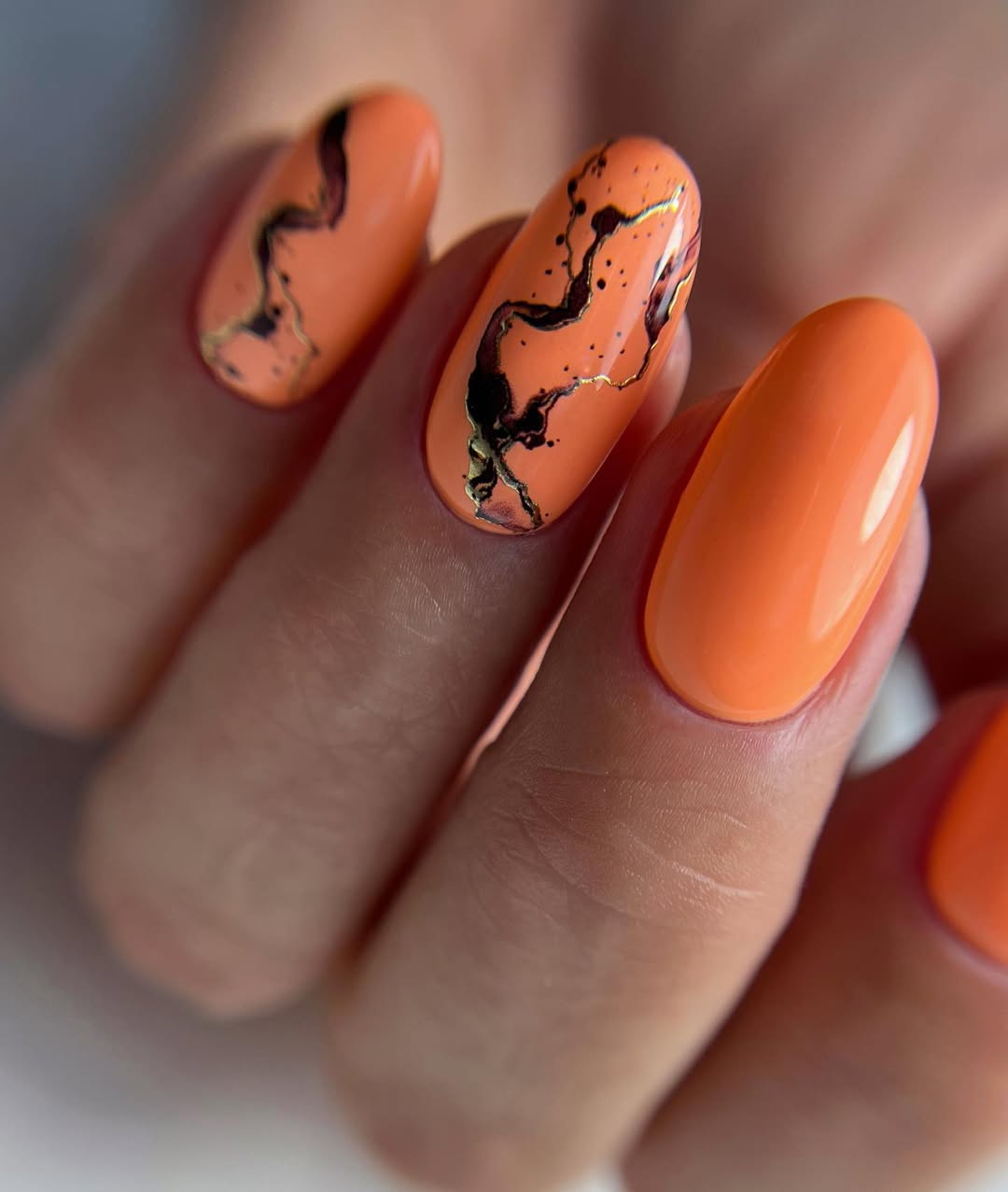 Vibrant Peach Gel Nails with Abstract Gold and Black Art