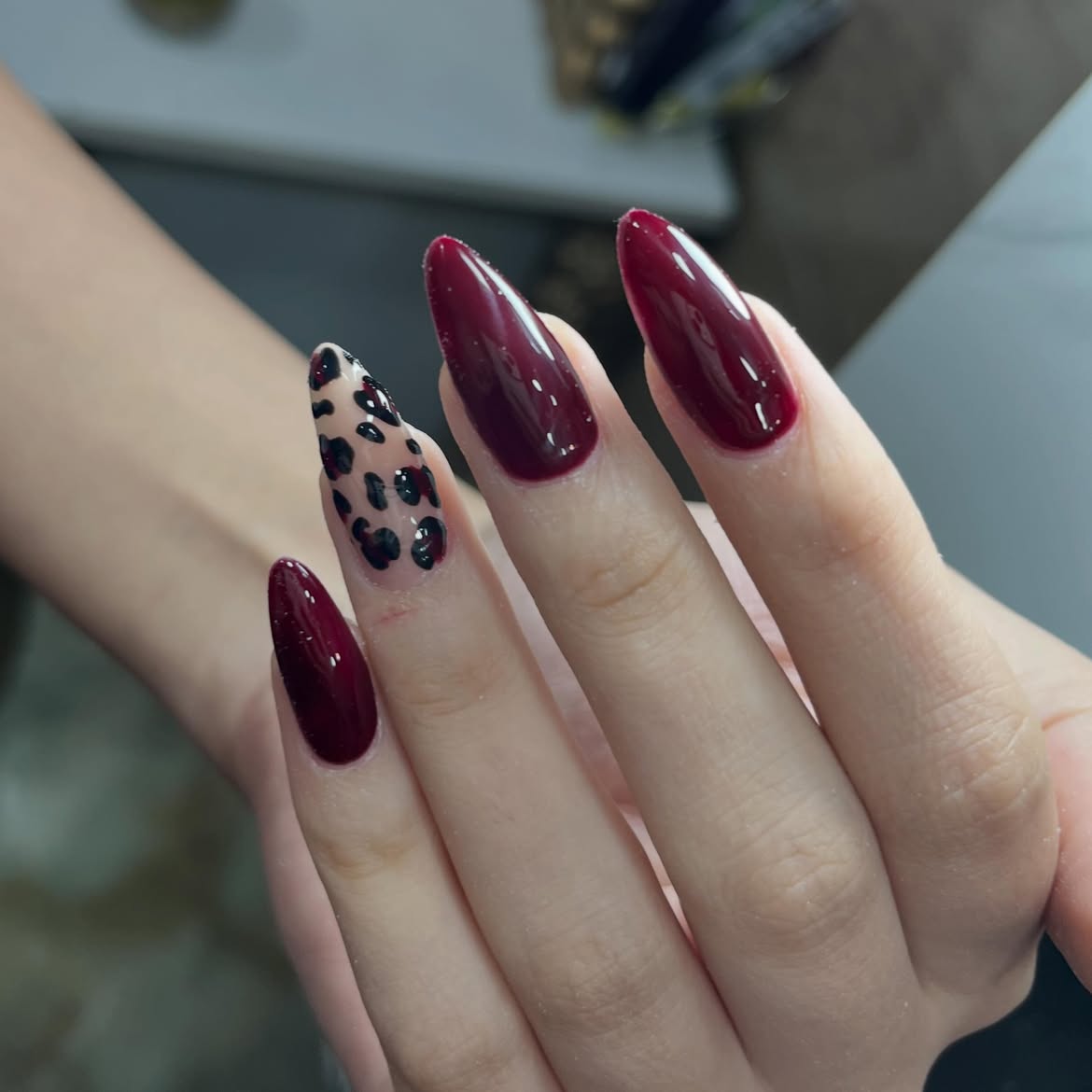 Deep Red Glossy Almond Nails with Leopard Accent