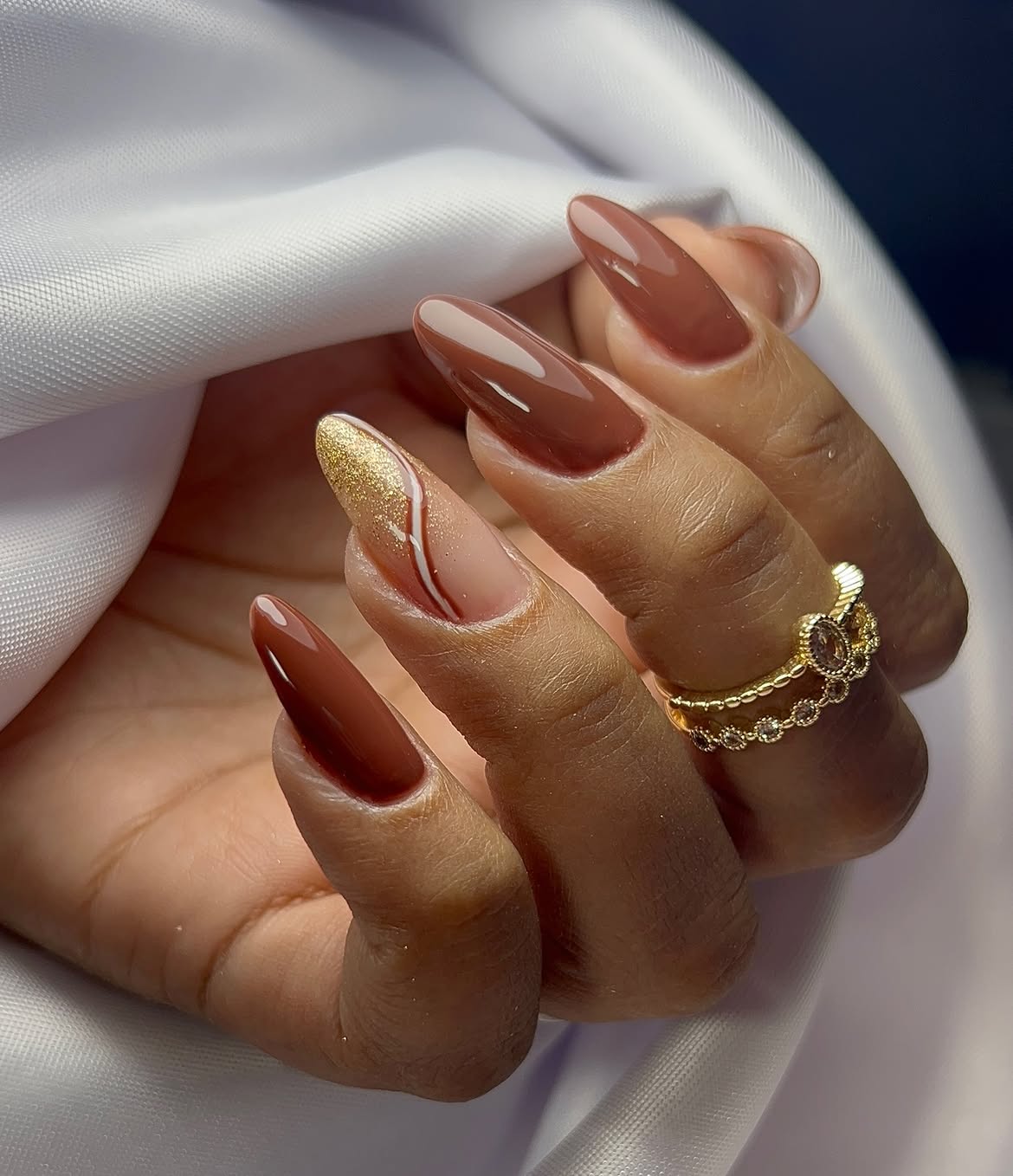Elegant Mocha Brown Almond Nails with Gold Swirl Accent