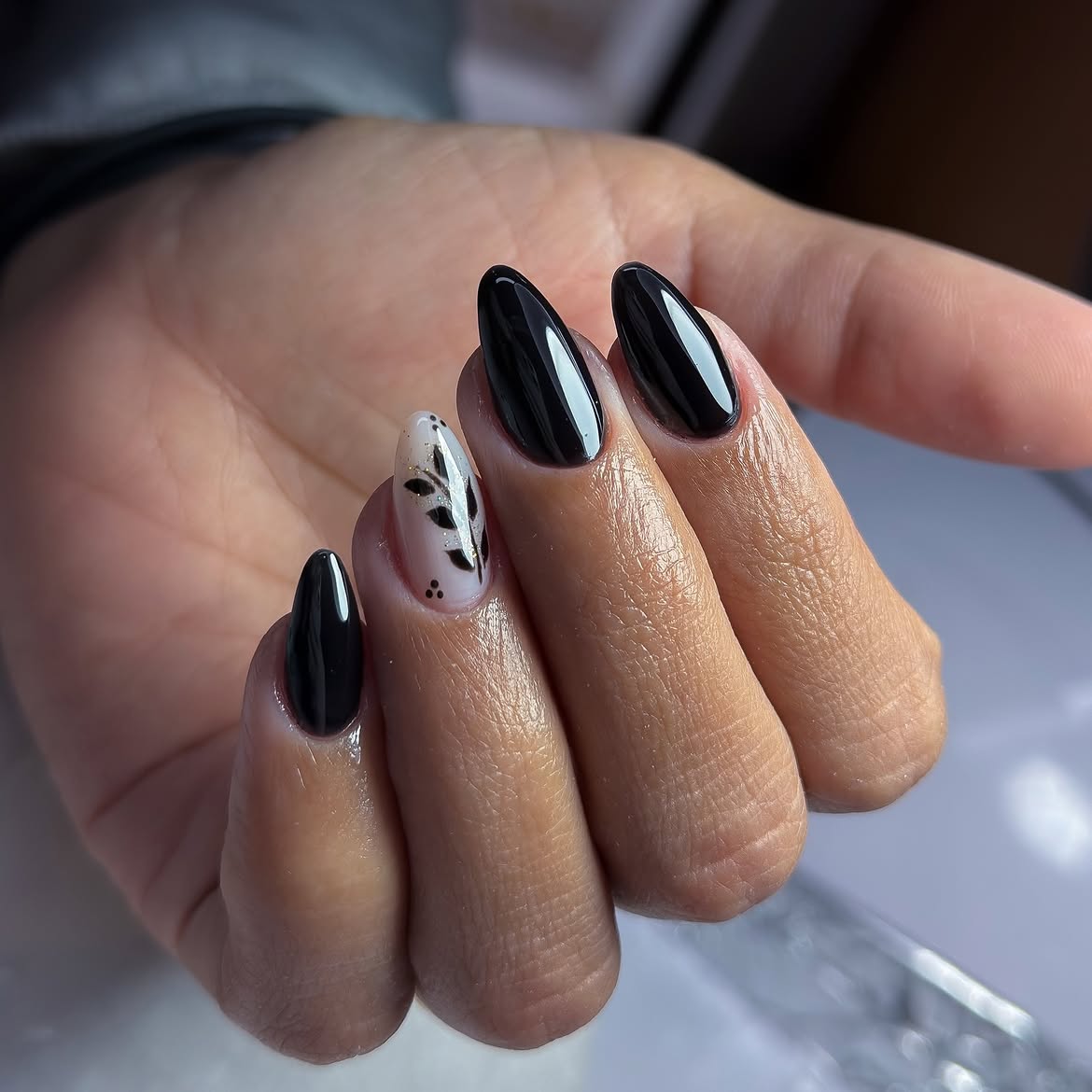 Glossy Black Almond Nails with Leaf Art