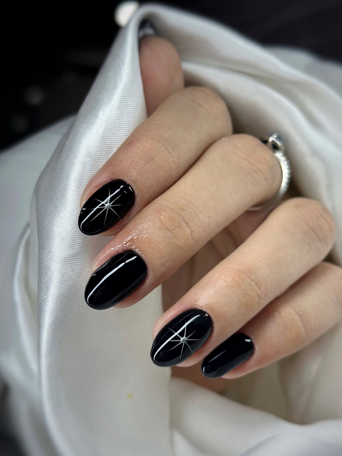 Glossy Black Oval Nails with Starburst Art