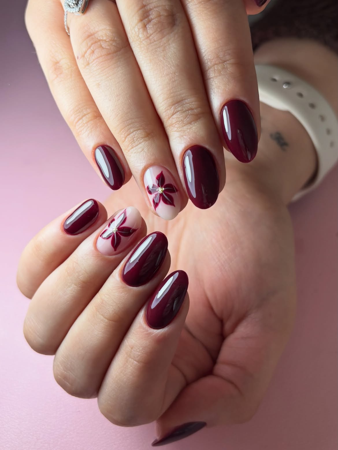 Glossy Burgundy Nails with Delicate Floral Accent