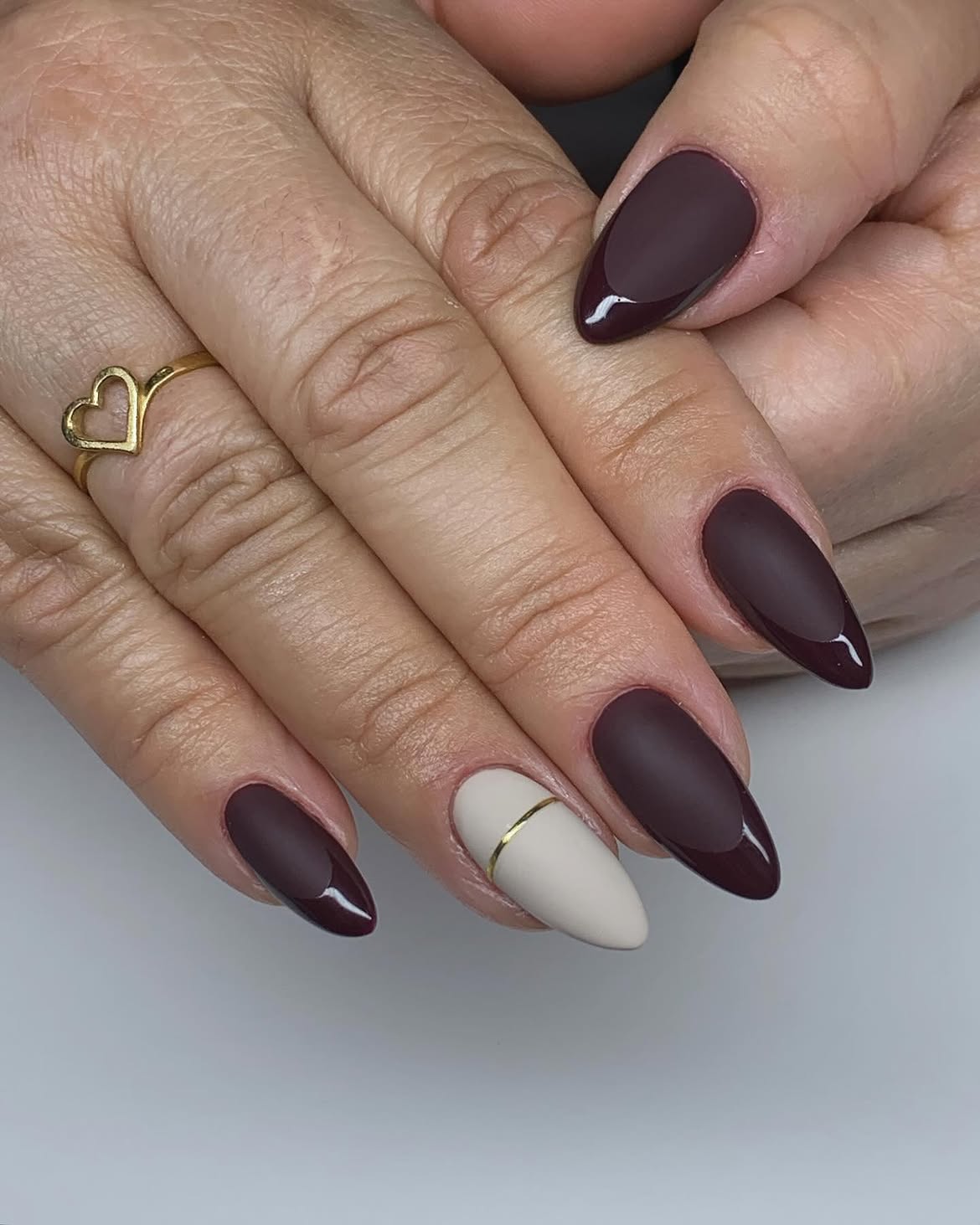 Matte Deep Berry Almond Nails with Gold Stripe