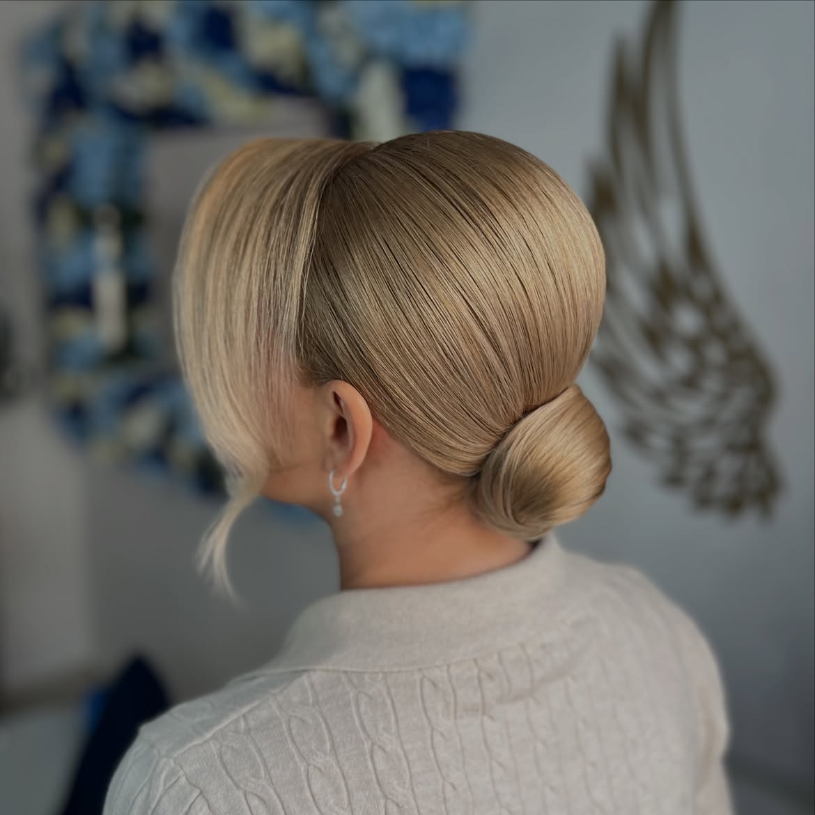 Sleek Blonde Low Bun With Face Framing Pieces