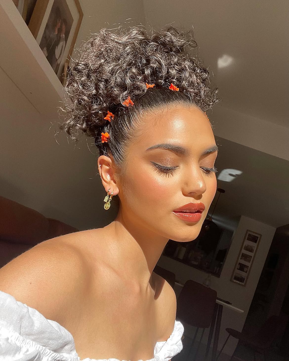 Chic High Curly Bun With Floral Accents