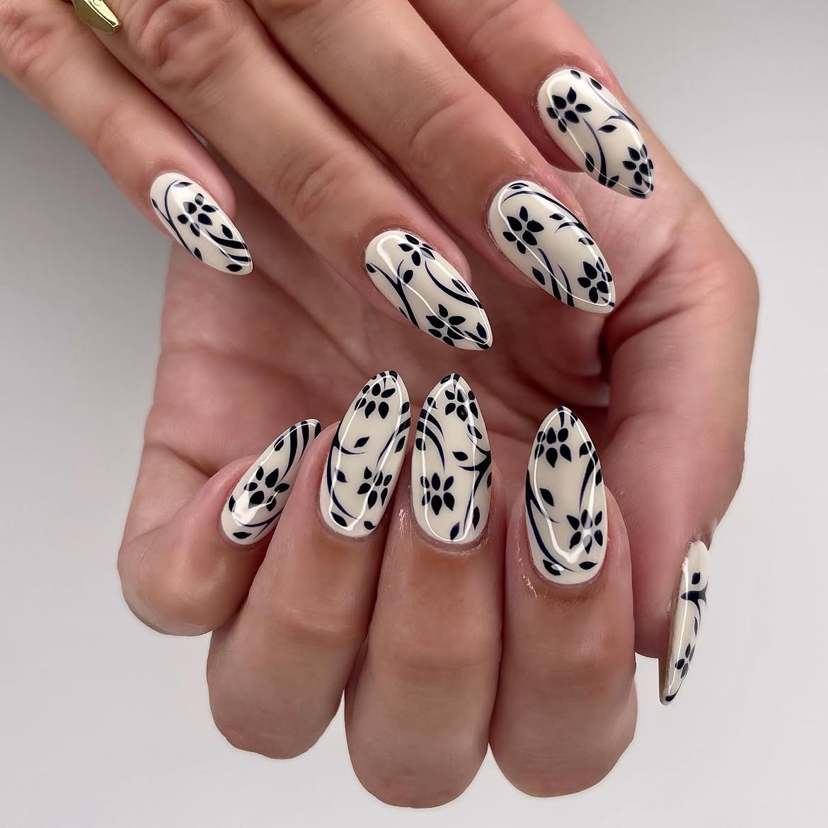 Creamy Almond Nails with Black Floral Swirls