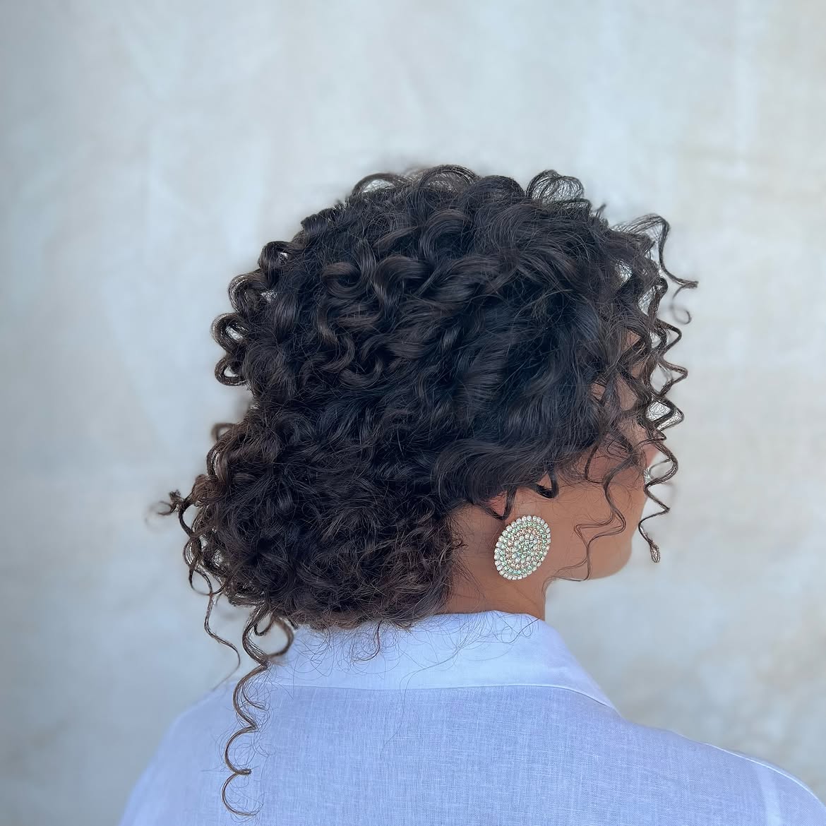 Effortless Curly Low Bun With Face-Framing Tendrils