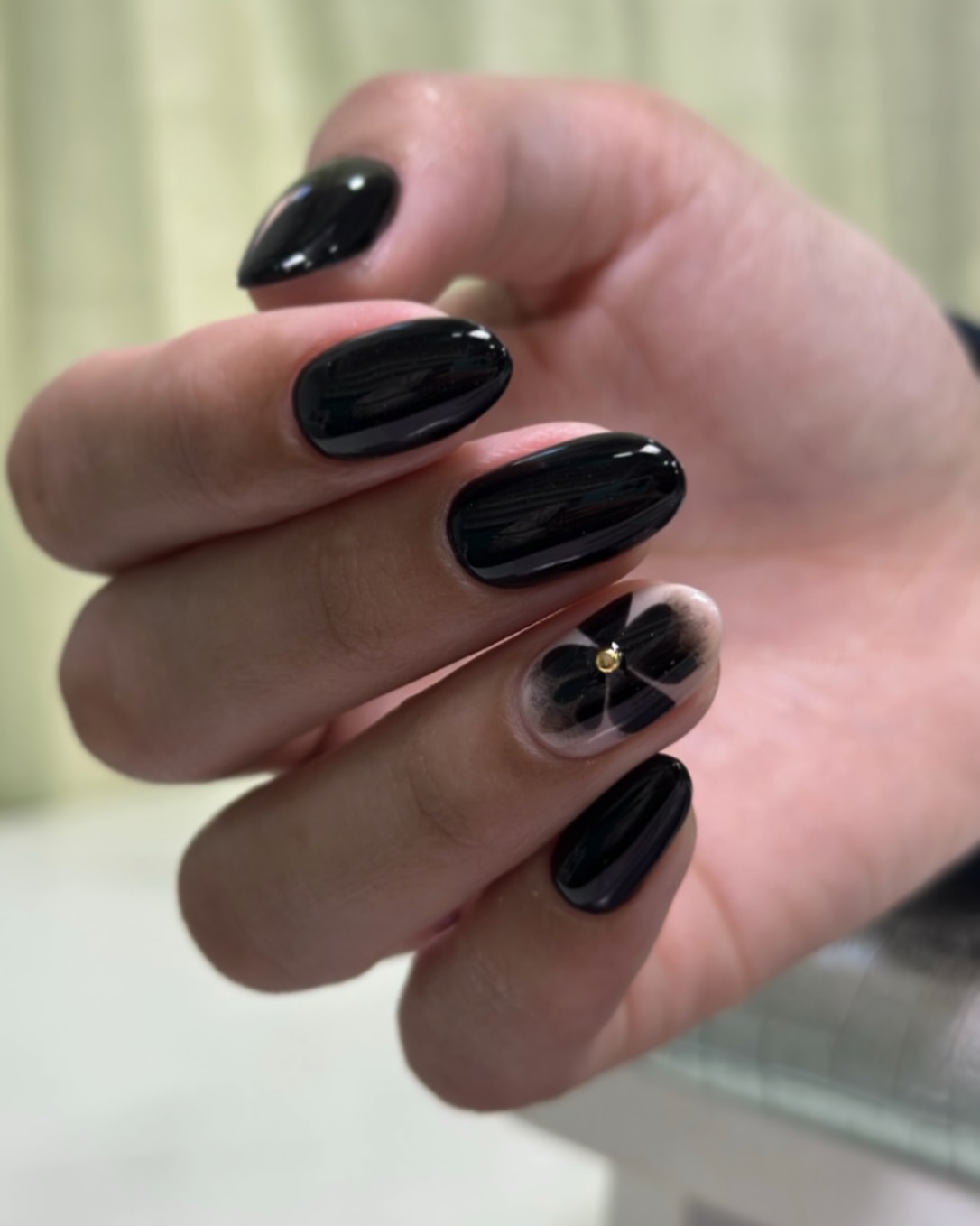 Glossy Black Oval Nails with Floral Accent