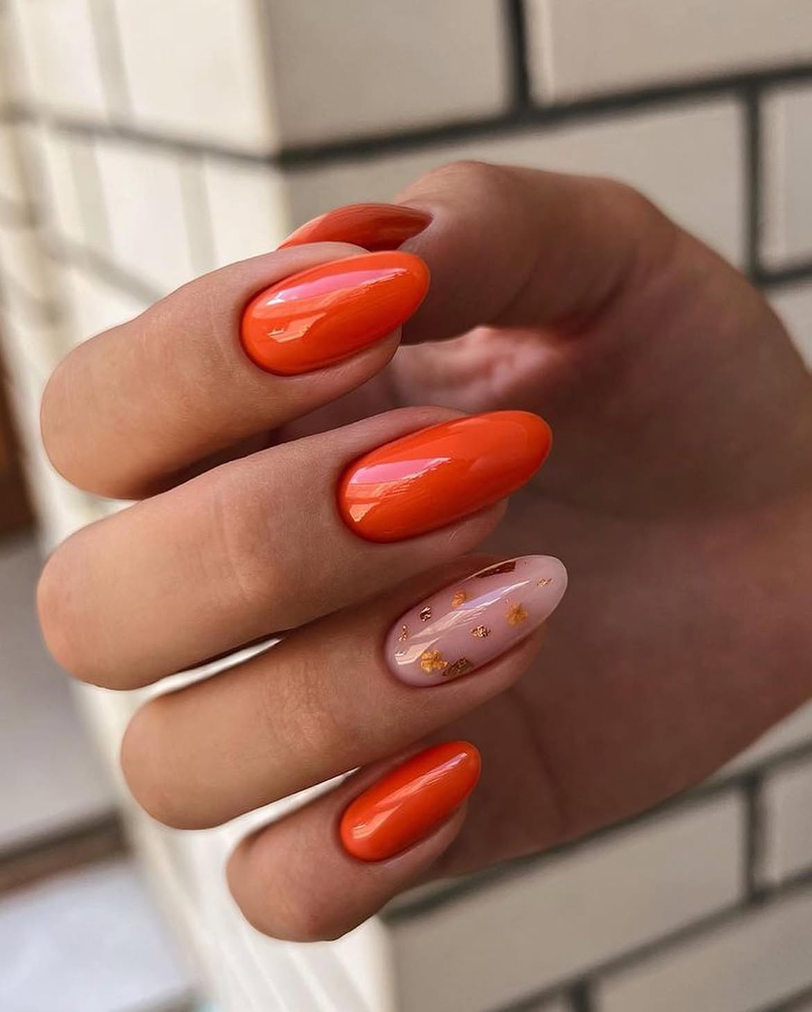 Glossy Tangerine Oval Nails With Gold Flakes