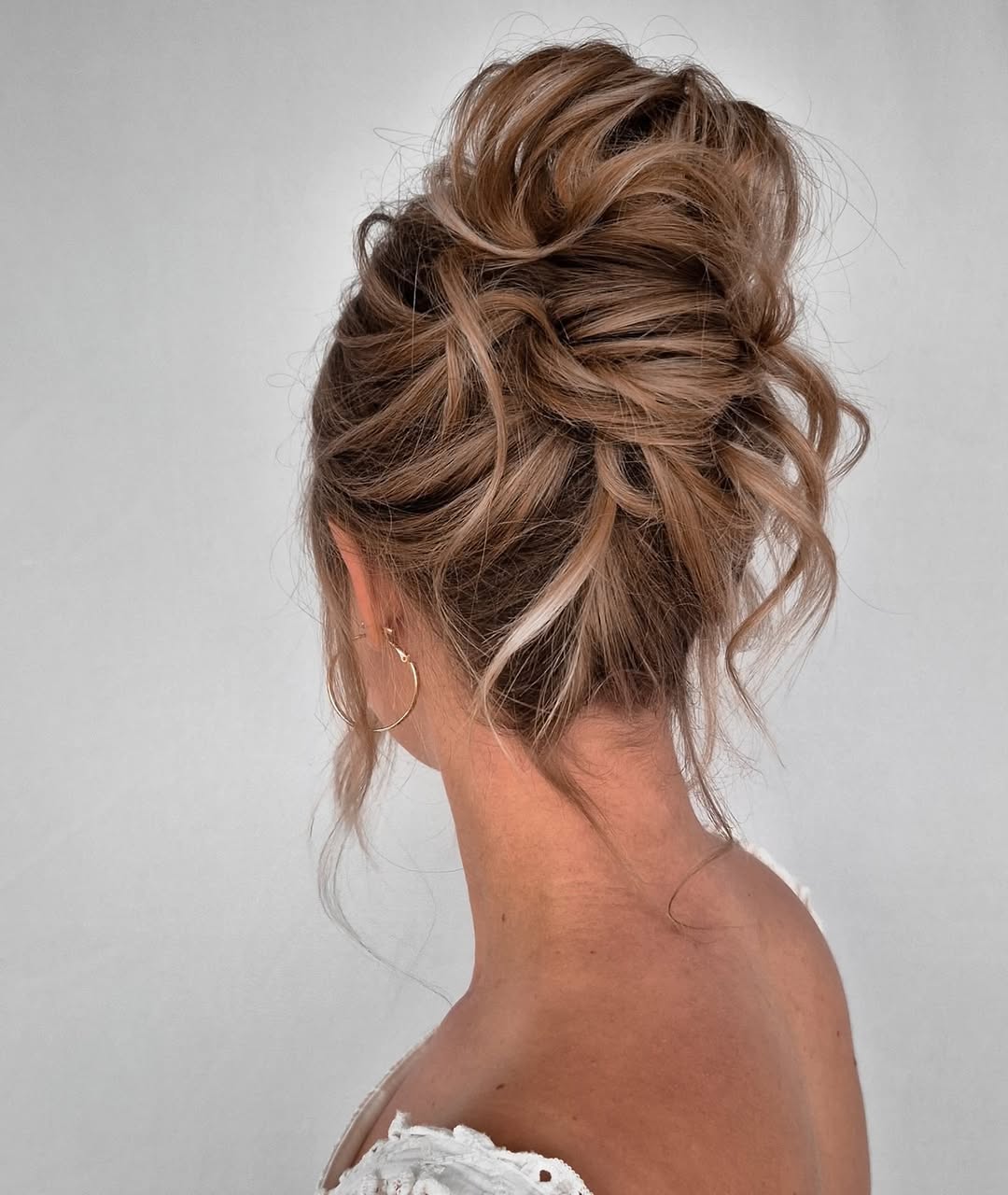 Messy Updo With Textured Waves And Face-Framing Pieces