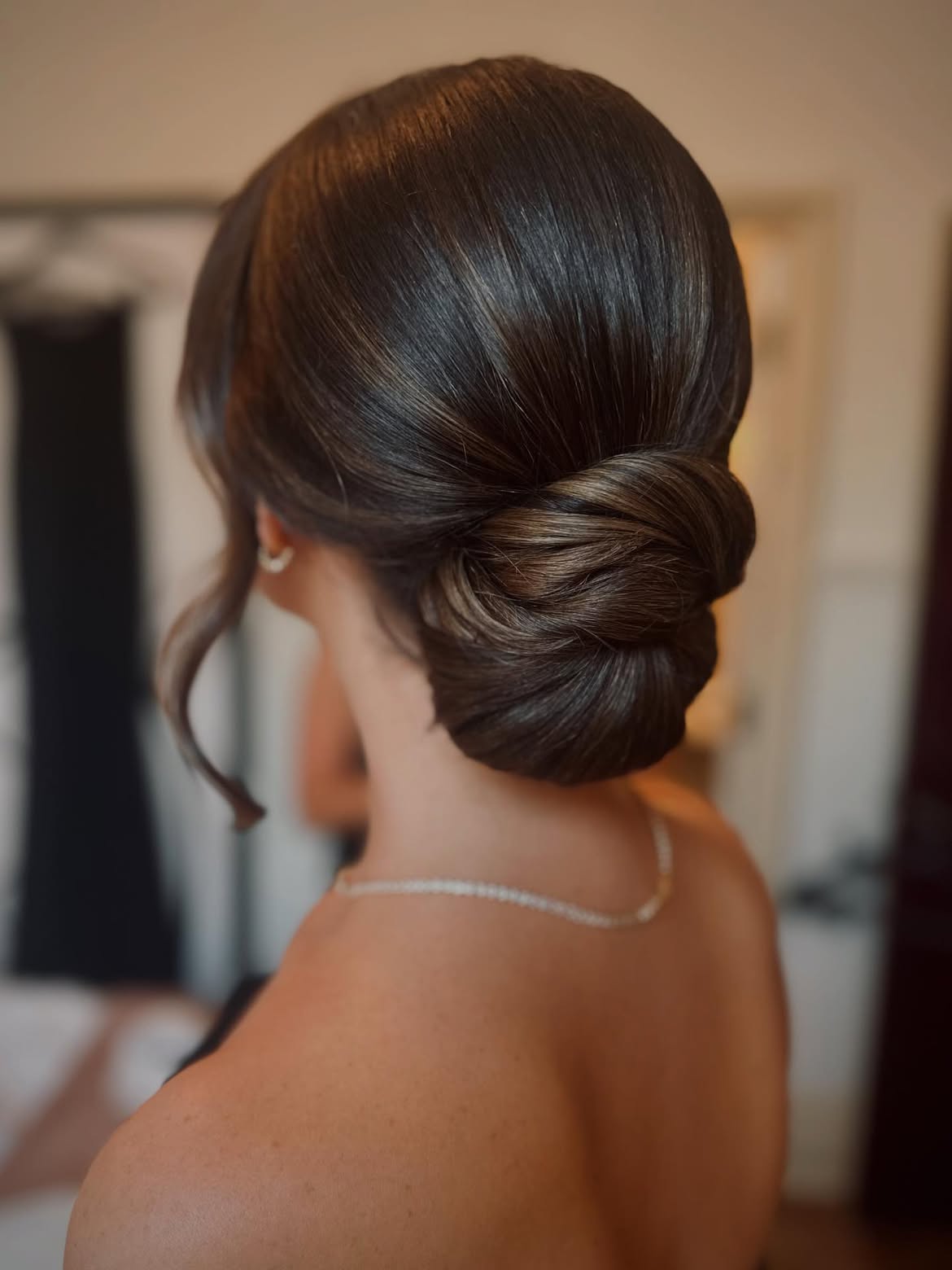 Polished Low Chignon With Face Framing Tendrils