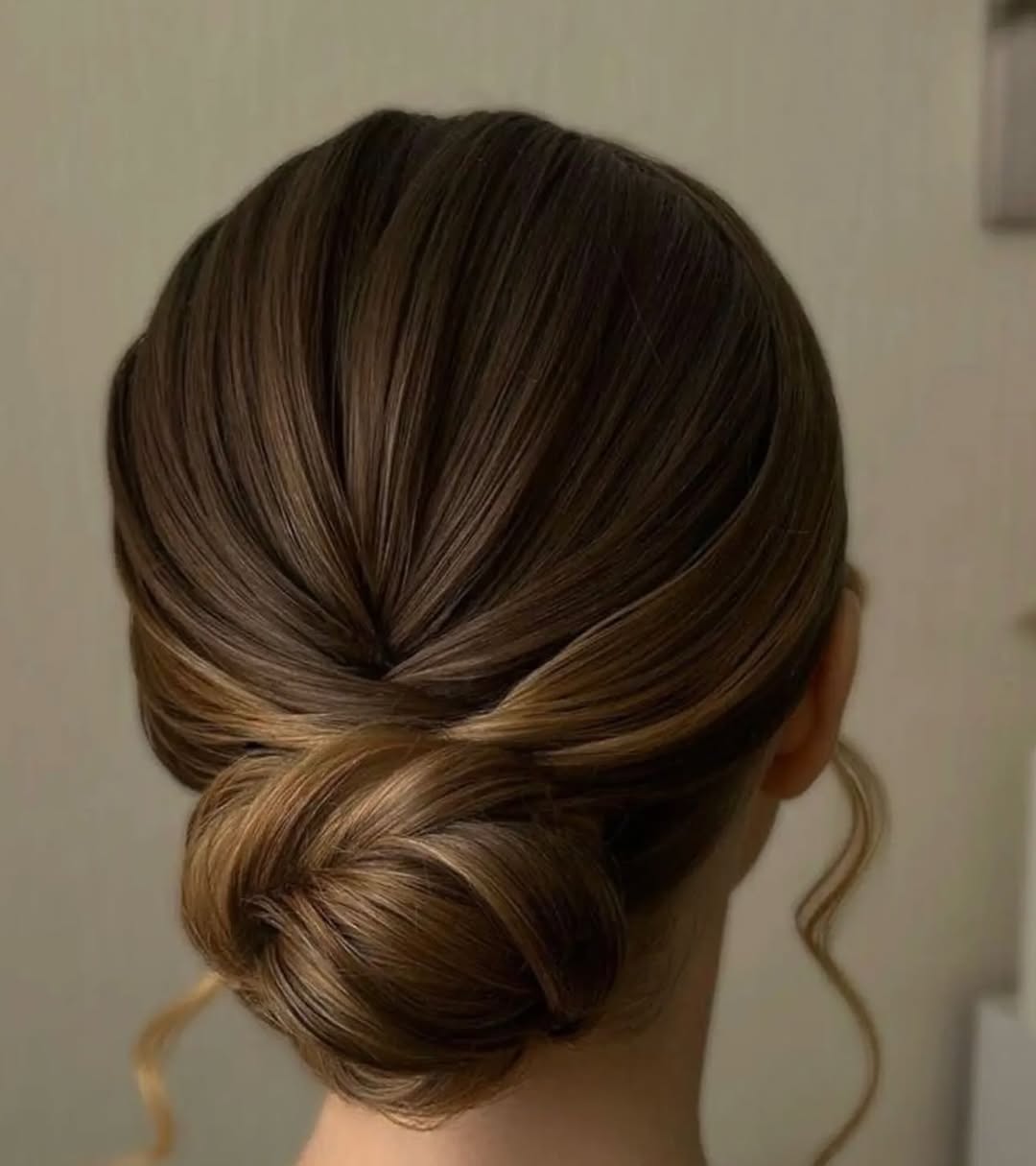 Polished Twisted Low Bun With Face Framing Tendrils