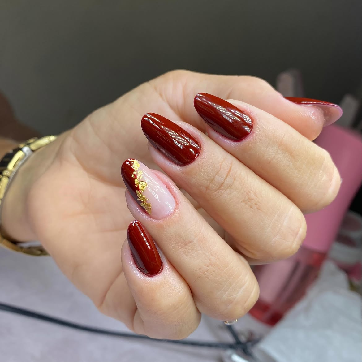 Rich Cherry Red Oval Nails with Gold Leaf Accent