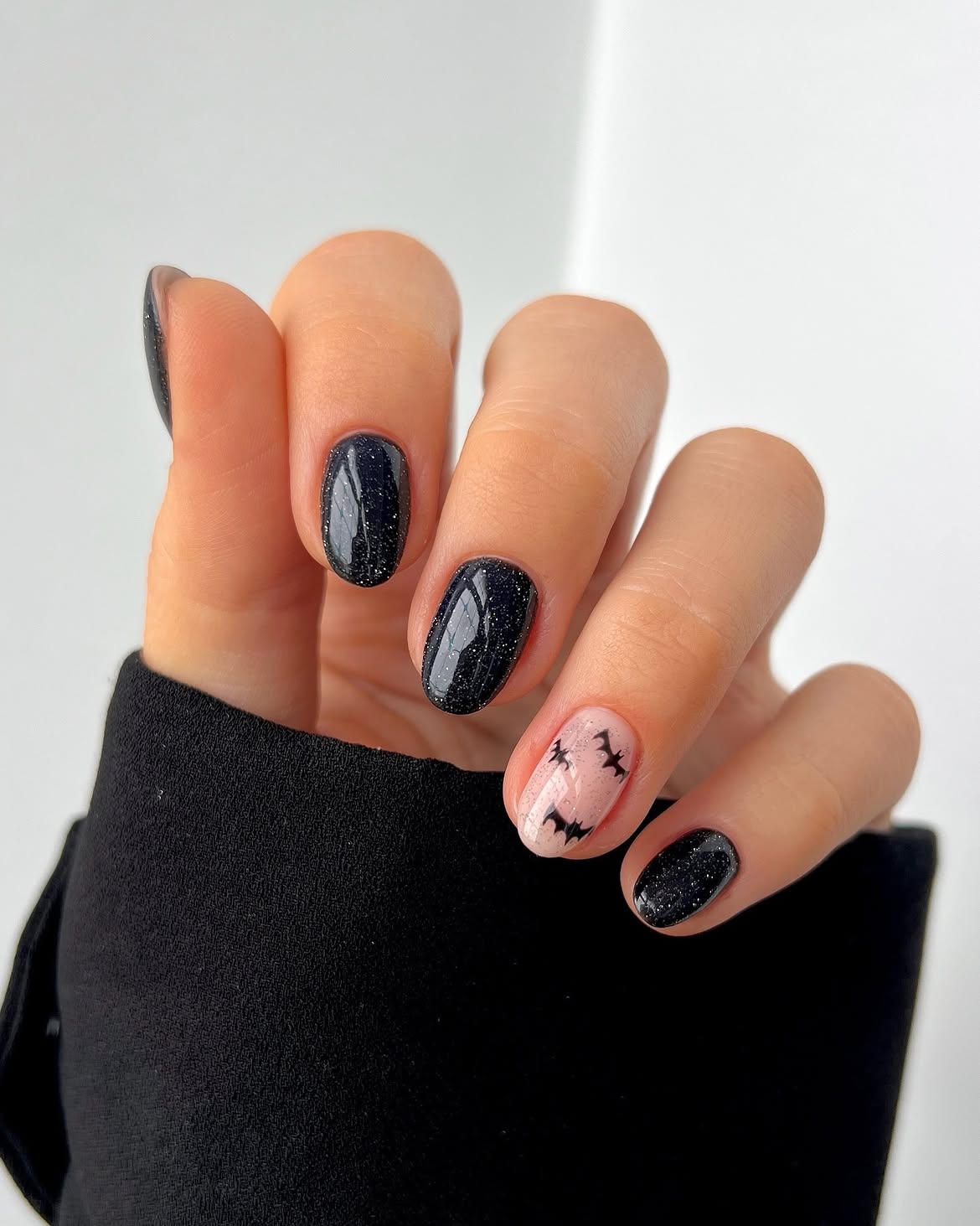 Sparkly Black Halloween Nails with Bat Accents
