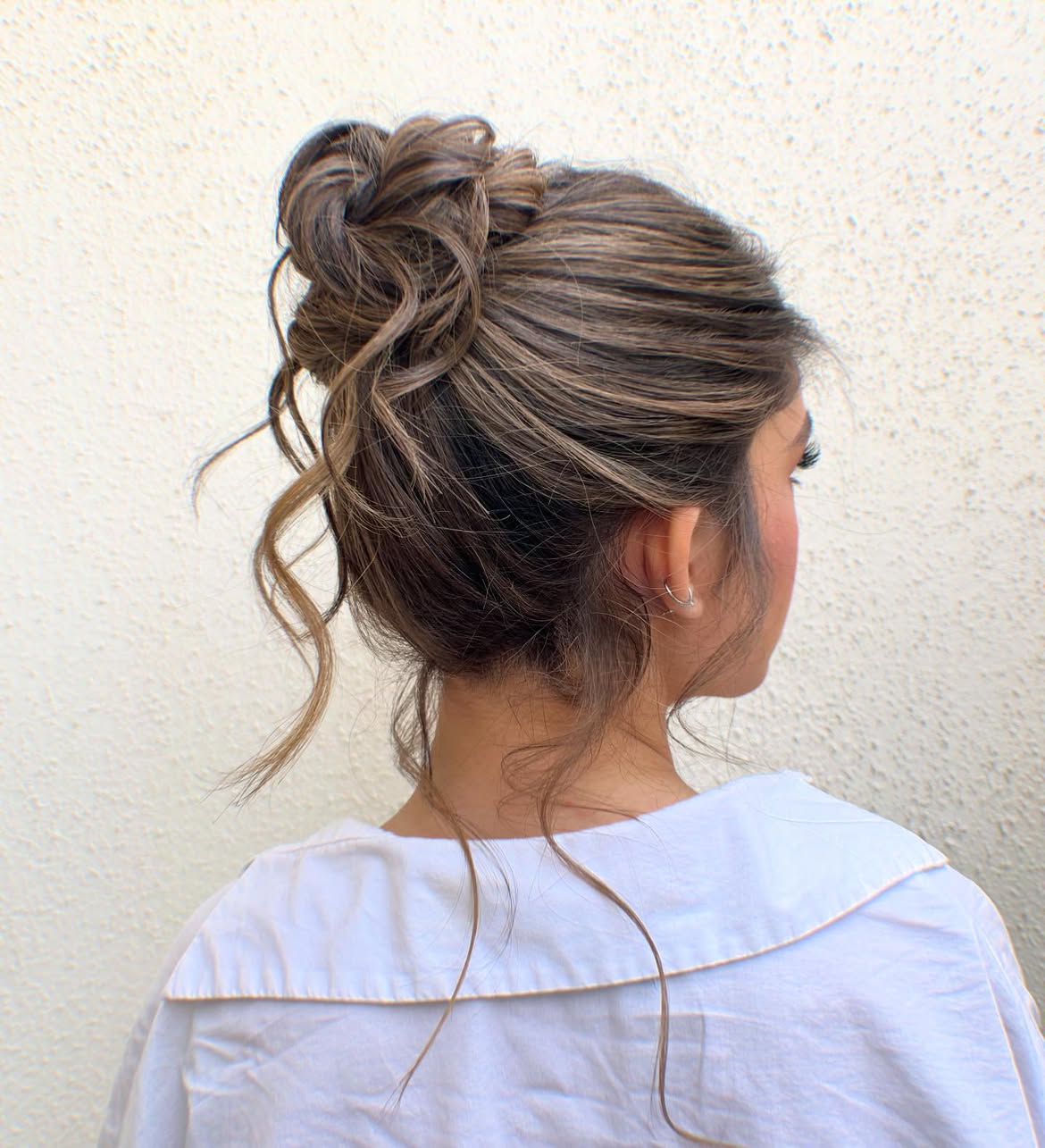 Tousled High Bun With Loose Face Framing Tendrils
