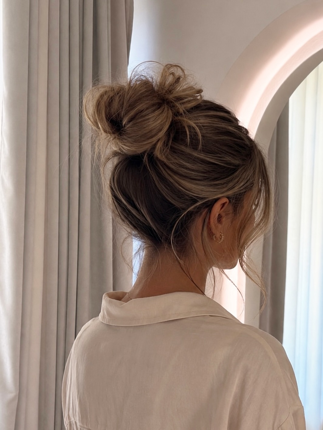 Tousled High Messy Bun With Face-Framing Strands