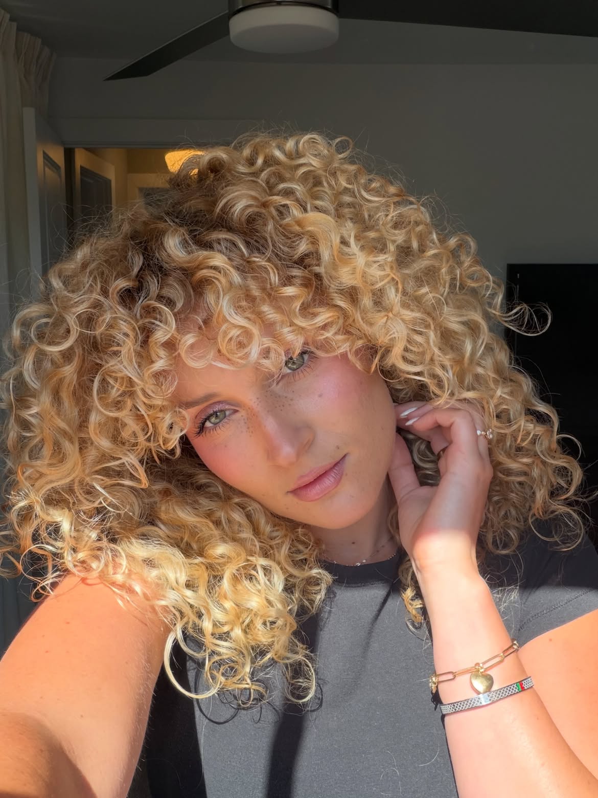 Tousled Honey Blonde Spiral Curls With Bangs