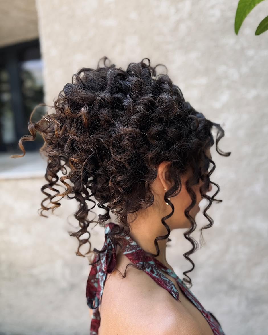 Voluminous Curly Updo With Soft Face Framing Tendrils