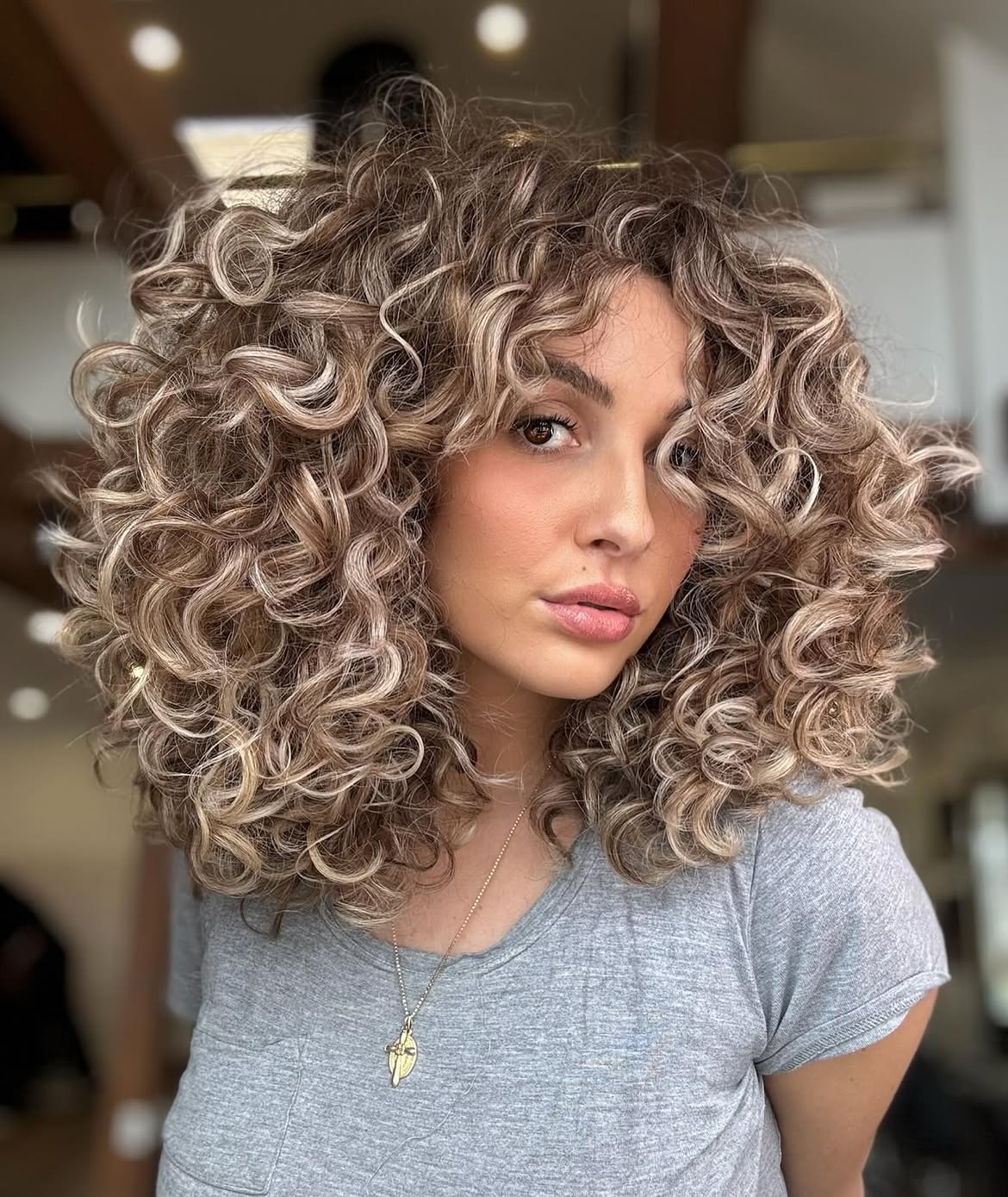 Voluminous Honey Blonde Curly Lob With Face-Framing Bangs