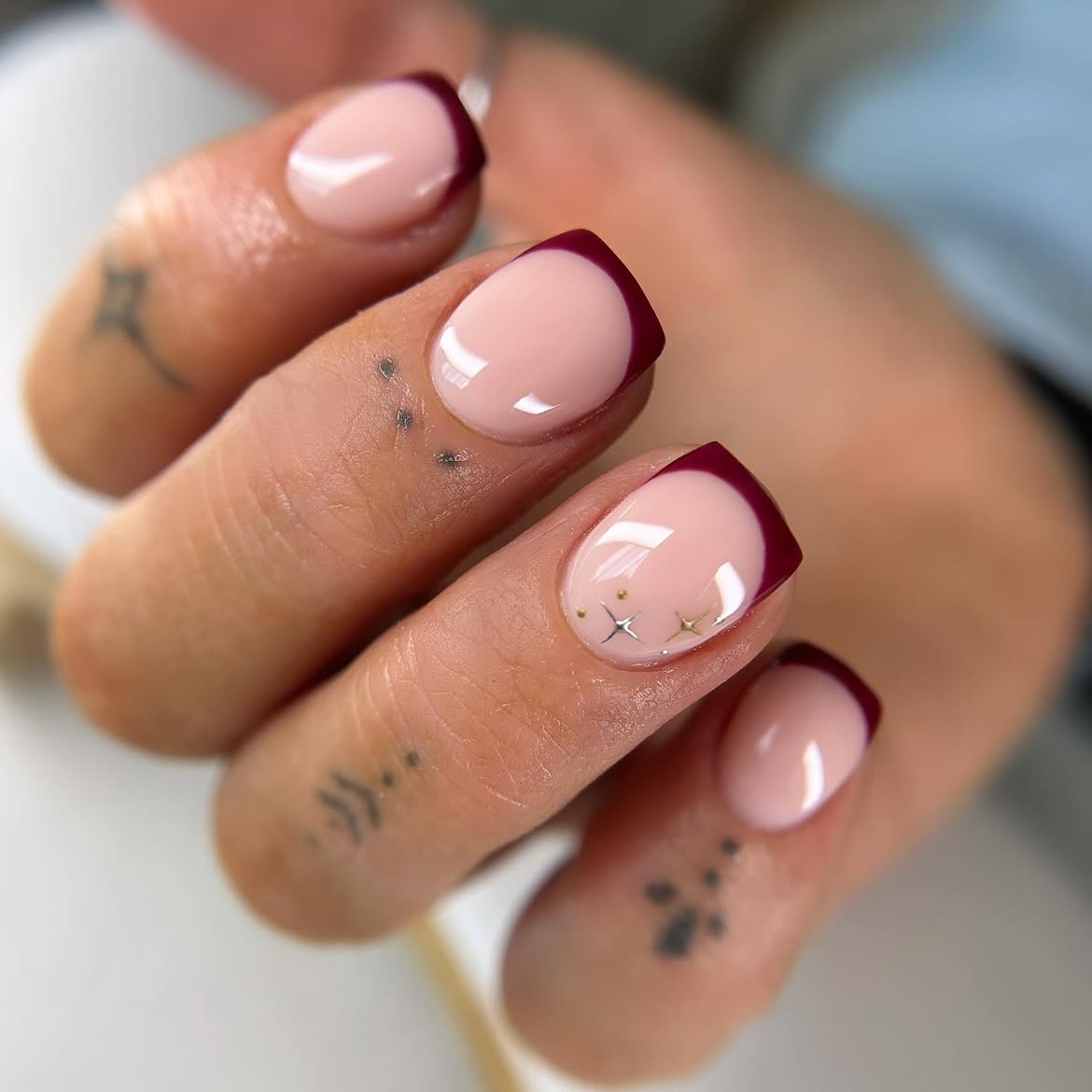 Burgundy French Tip Nails with Gold Star Accents