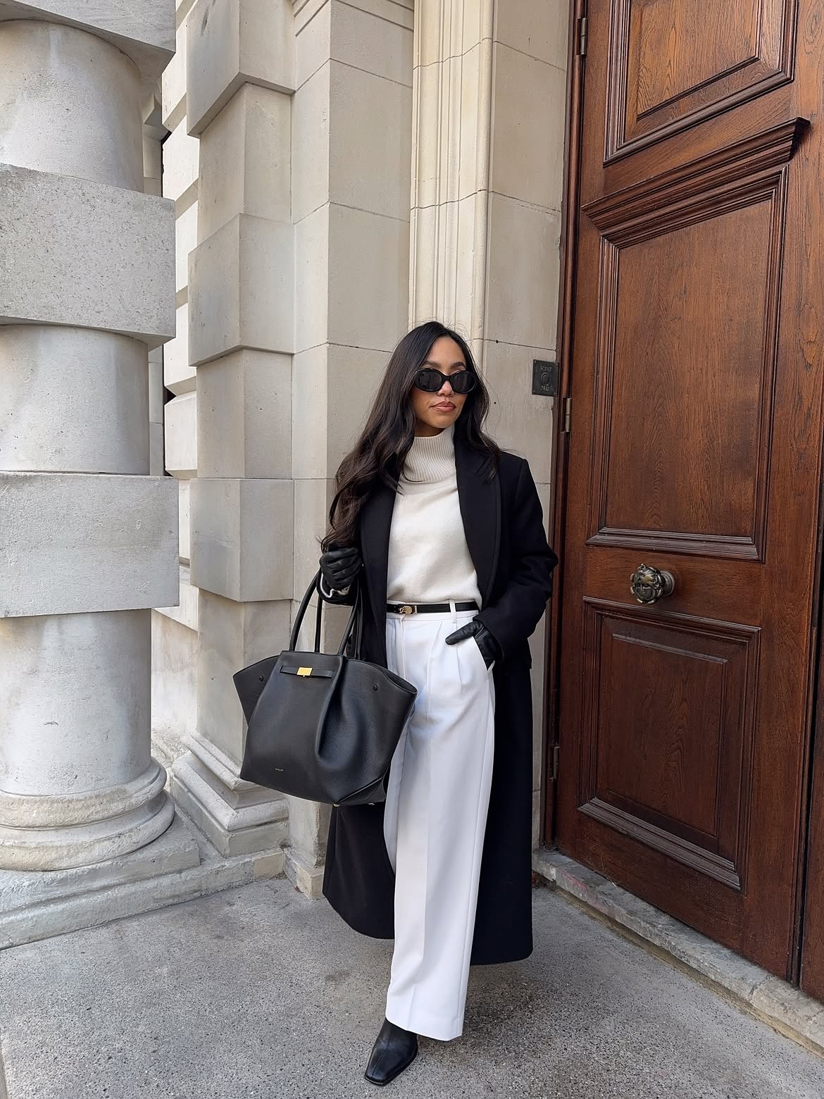 Chic Black Wool Coat Over Cream Turtleneck and White Trousers