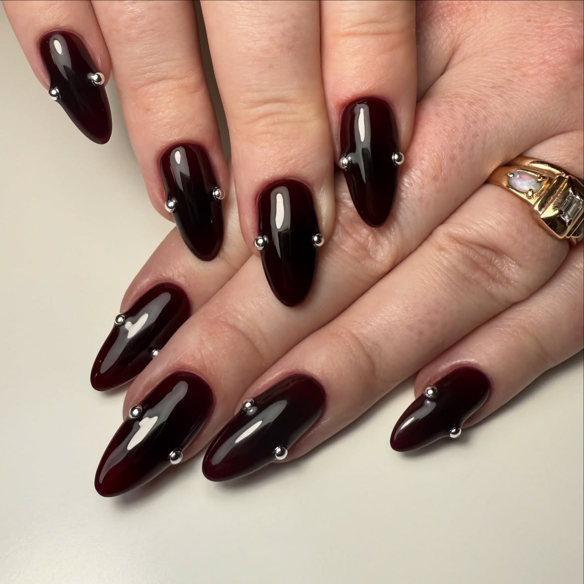 Deep Burgundy Glossy Stiletto Nails with Silver Studs