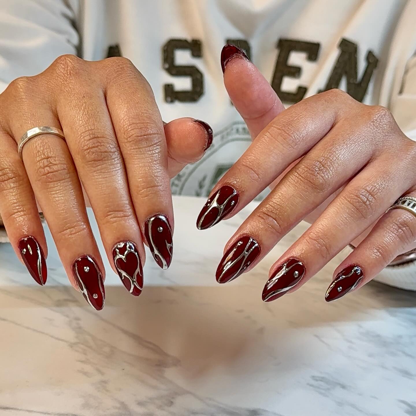 Deep Burgundy Stiletto Nails with Silver Swirl Art