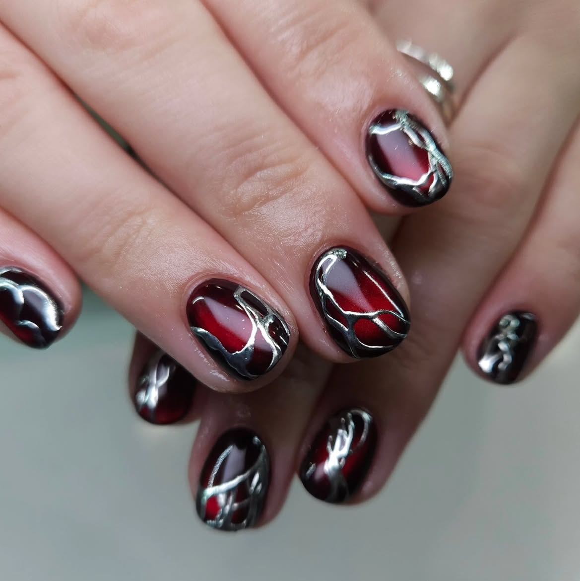Glossy Burgundy and Silver Swirl Oval Nails