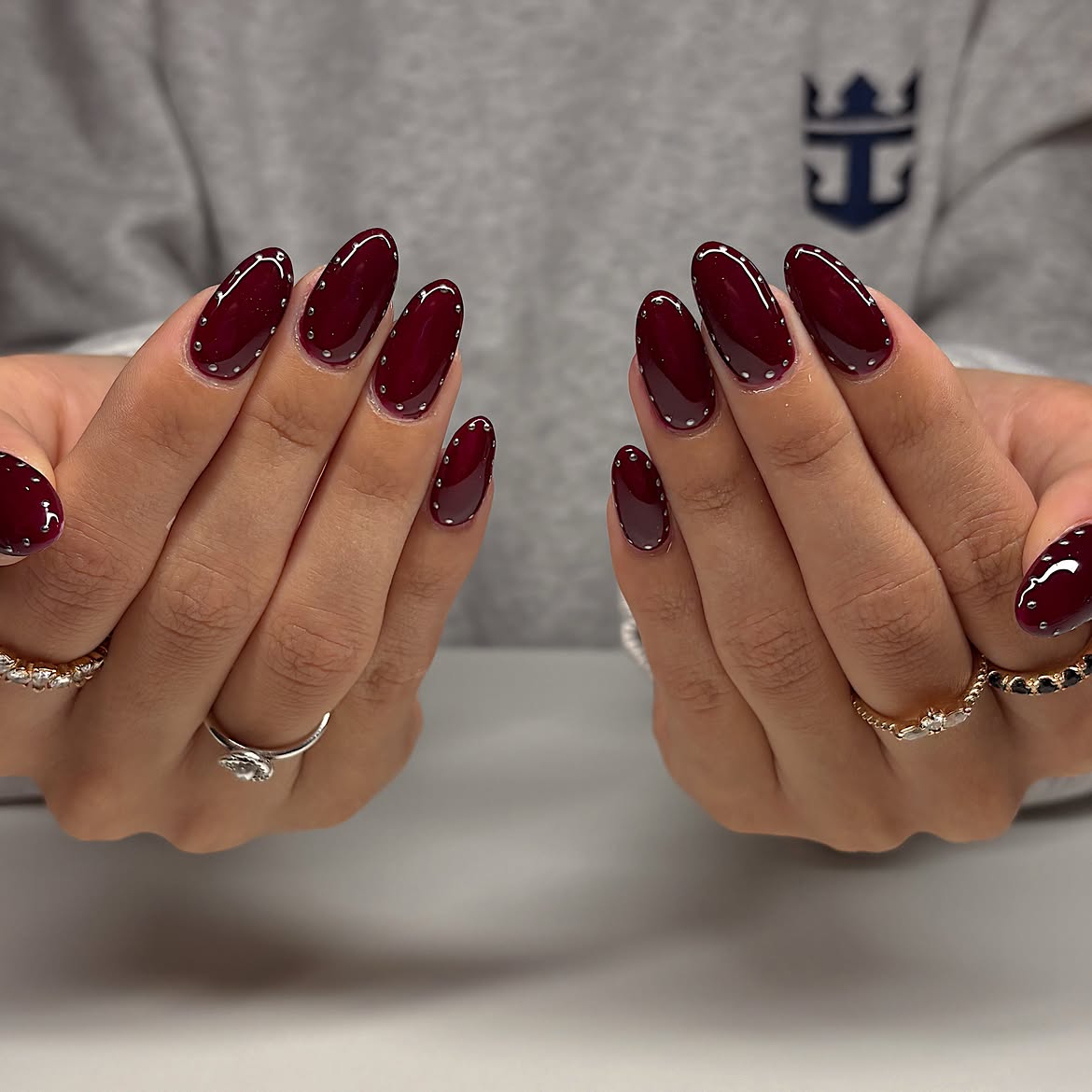Glossy Burgundy Oval Nails with Silver Studs