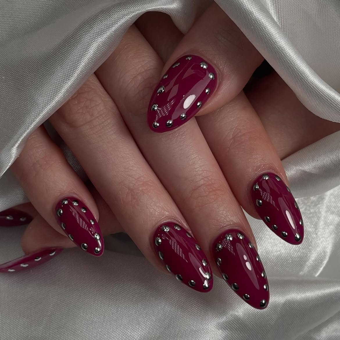 Glossy Burgundy Stiletto Nails with Silver Studs