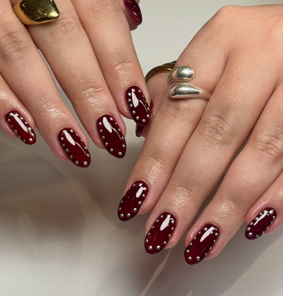 Glossy Deep Burgundy Oval Nails with Silver Studs