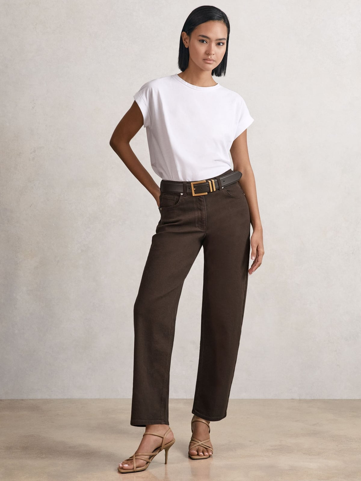 Dark brown straight leg jeans with white t-shirt and tan sandals Dark brown straight leg jeans with white t-shirt and tan sandals — Brown Jeans Outfits