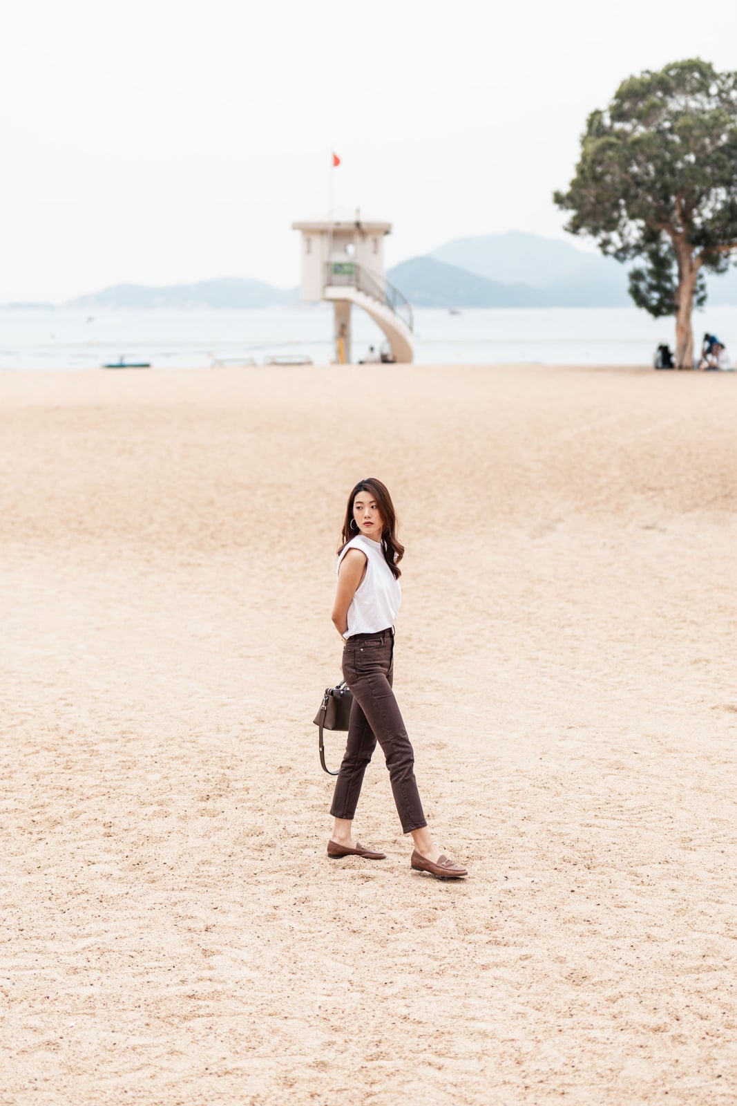 Dark chocolate brown straight leg jeans on a beach Dark chocolate brown straight leg jeans on a beach — Brown Jeans Outfits