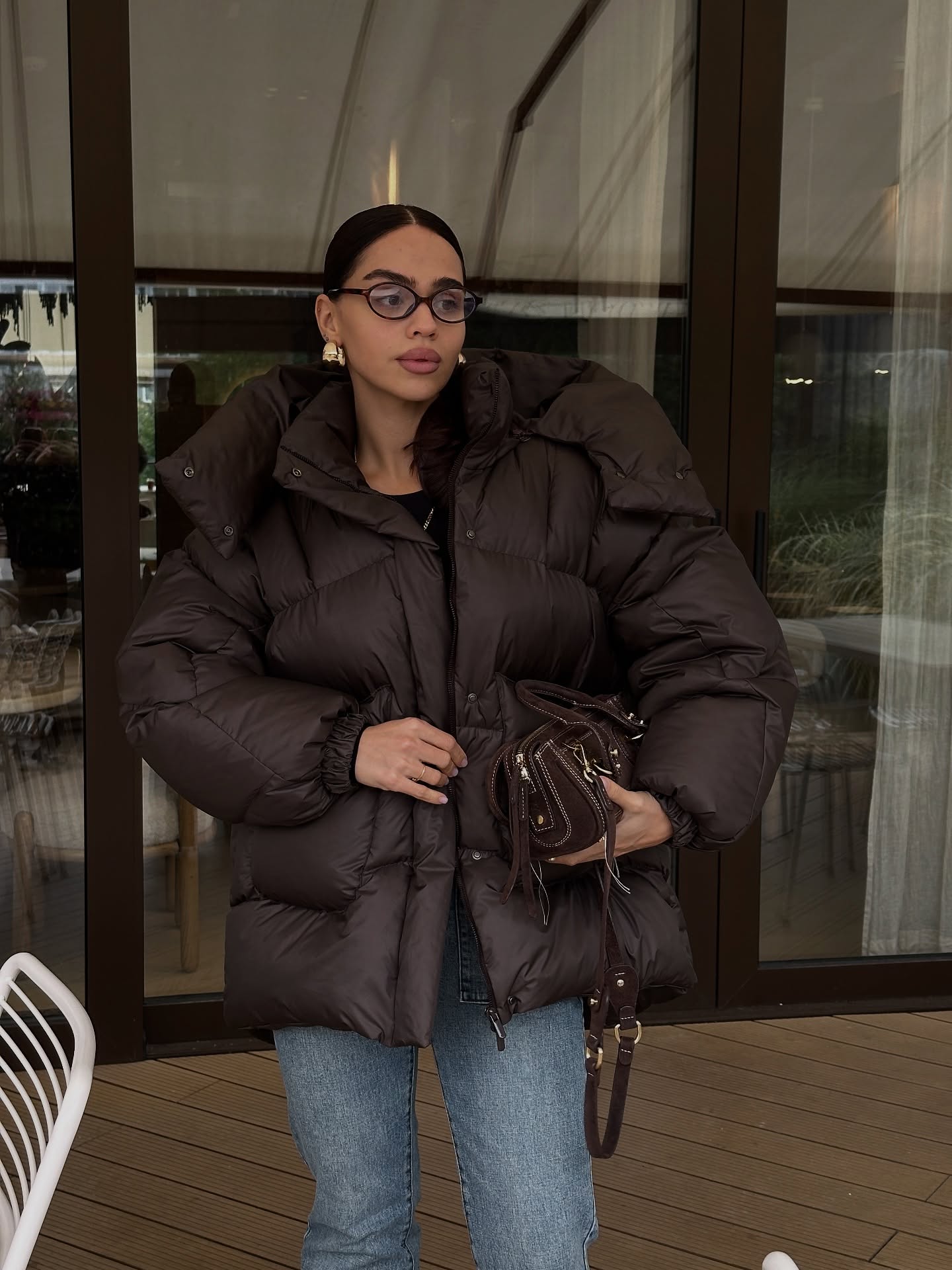 Brown Puffer Jacket With Blue Jeans And Mini Bag