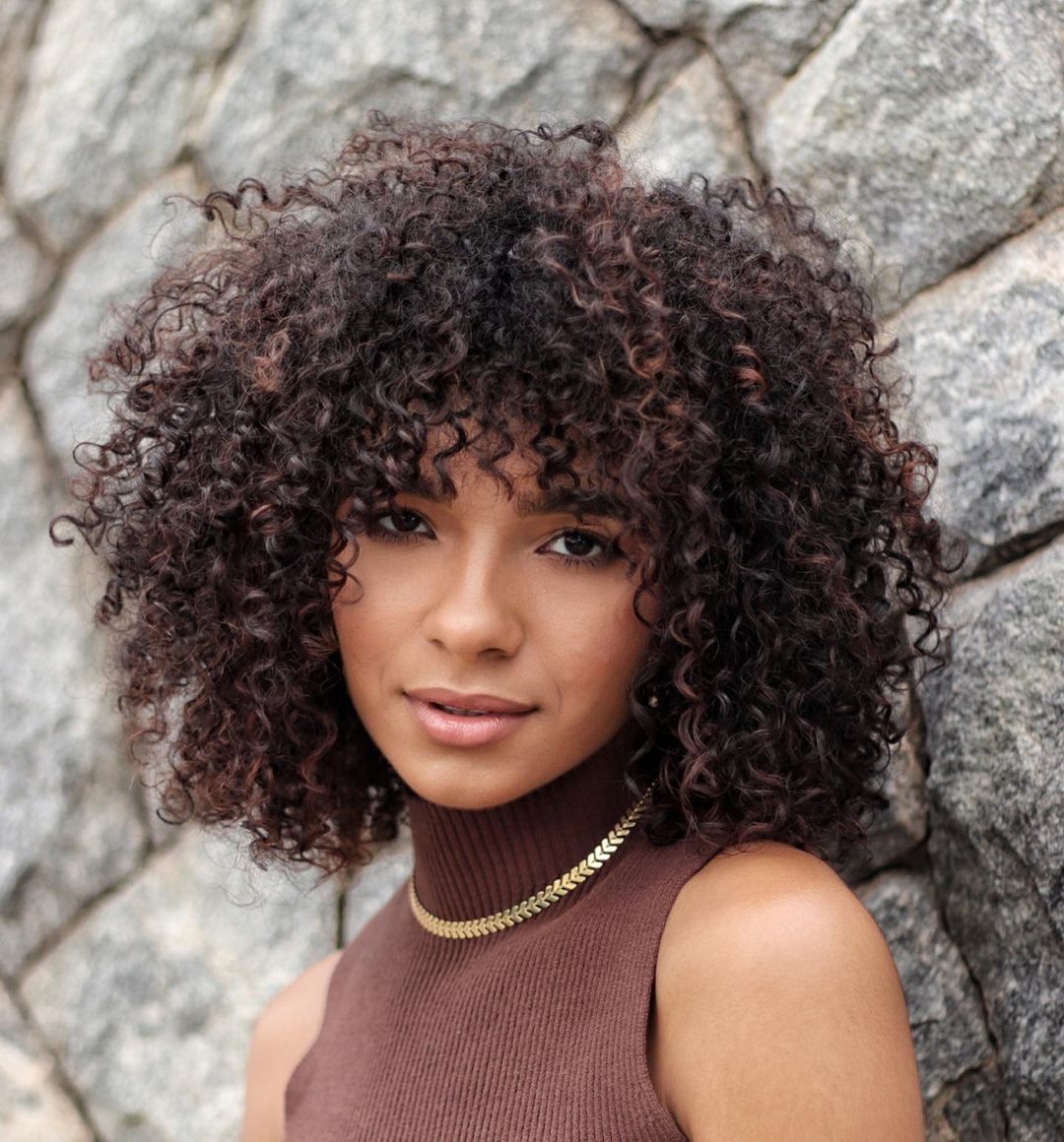 Collarbone Curly Hair With Auburn Highlights and Full Curly Bangs Collarbone Curly Hair With Auburn Highlights and Full Curly Bangs — Curly Hair with Bangs