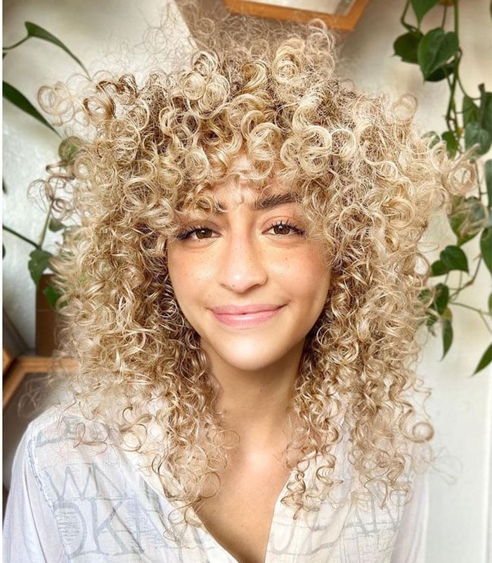 Shoulder-Length Ash Blonde Shag With Root Shadow and Curly Bangs Shoulder-Length Ash Blonde Shag With Root Shadow and Curly Bangs — Curly Hair with Bangs