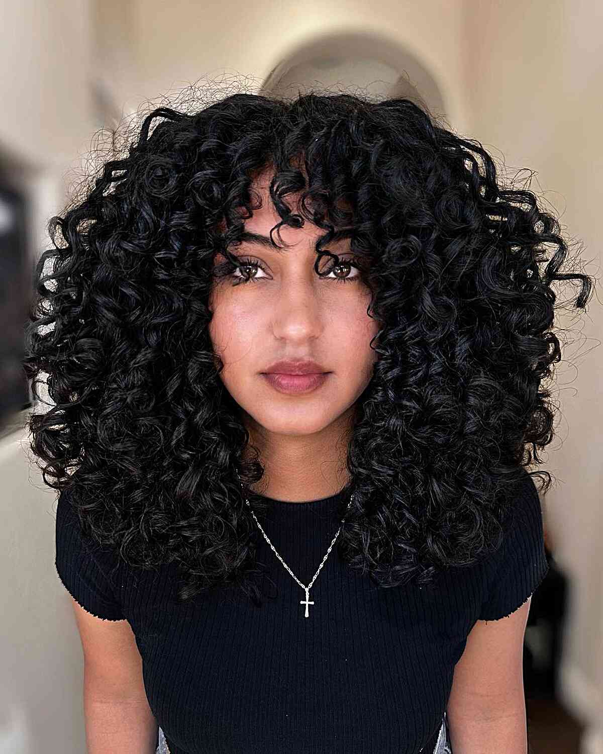 Collarbone Shag With Voluminous Curls and Curtain Bangs Collarbone Shag With Voluminous Curls and Curtain Bangs — Curly Hair with Bangs
