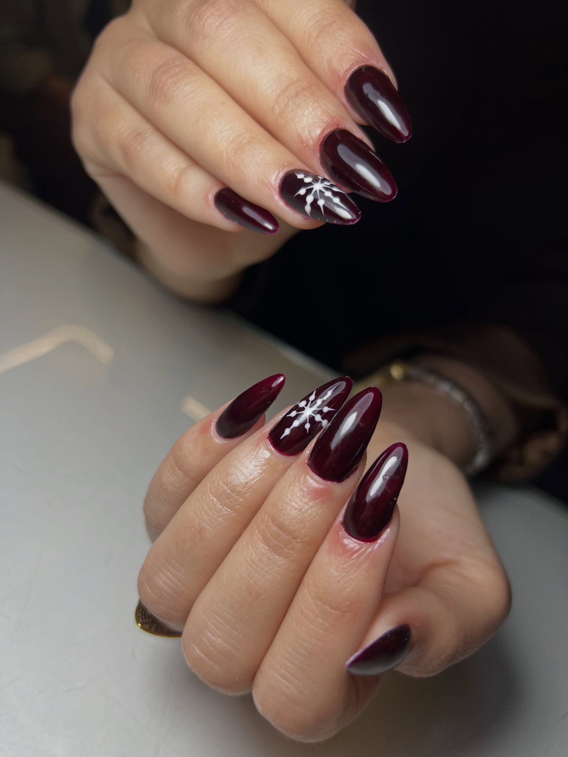 Deep Burgundy Stiletto Nails with White Snowflakes