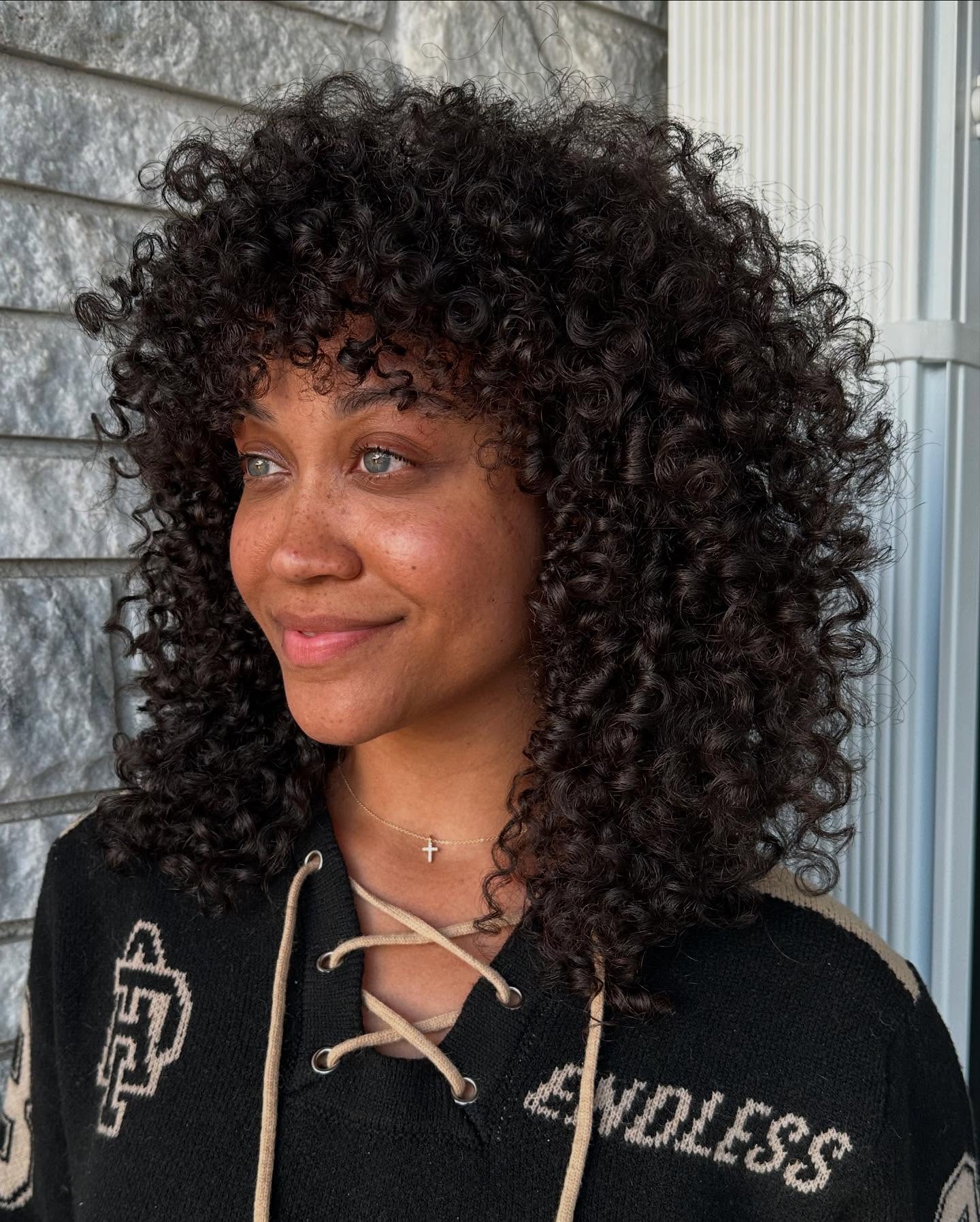 Defined Curly Cut With Face-Framing Bangs