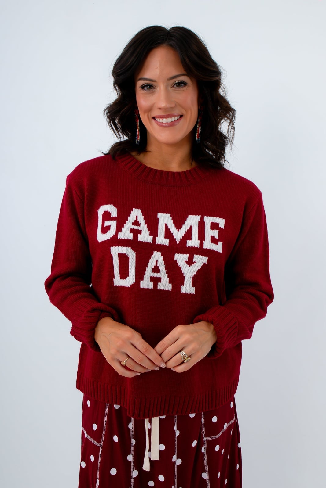 Red crewneck sweater with polka dot bottoms and statement earrings Red crewneck sweater with polka dot bottoms and statement earrings — Game Day Outfits