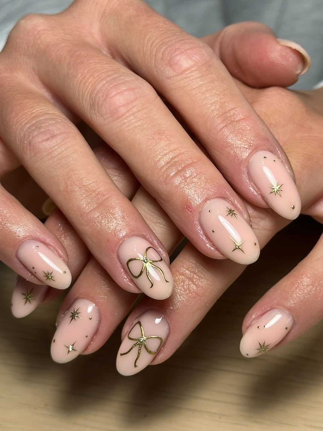 Glossy Milky Nude Nails With Gold Stars And Bows