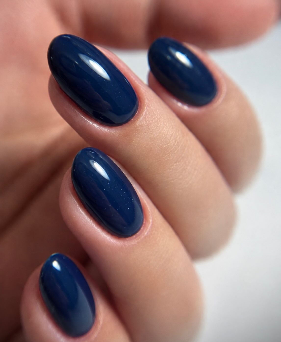 Glossy Navy Blue Oval Nails with Subtle Sparkle