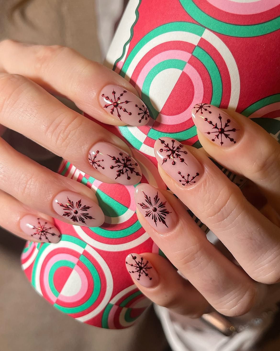 Glossy Nude Almond Nails With Red Snowflake Art
