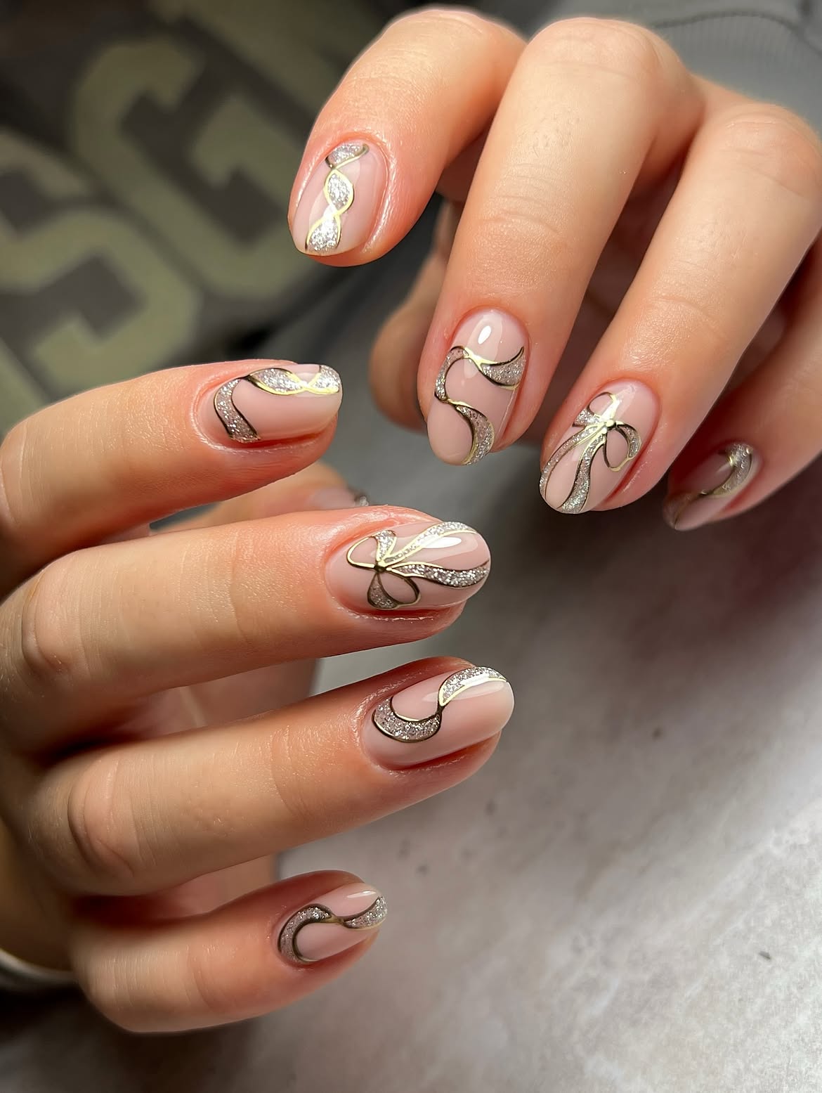 Glossy Nude Nails with Gold and Silver Bow Art